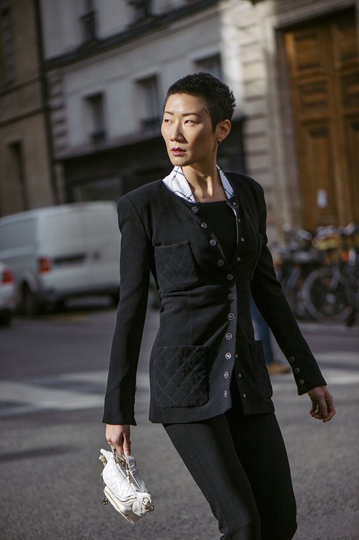 黑色修身外套、格紋無袖上衣、黑色連身七分褲、皮革腰包，all by Chanel。