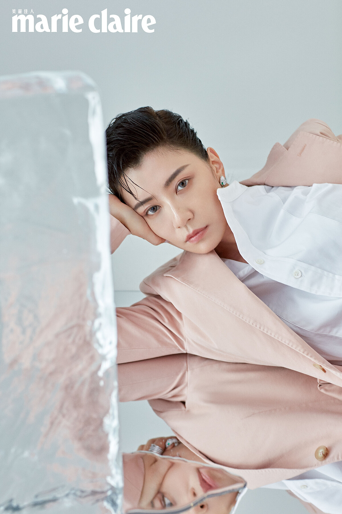 白色襯衫、粉色西裝外套，both by Polo Ralph Lauren；頂級鑽石與祖母綠鑲嵌 Serpenti 耳環，Bulgari。