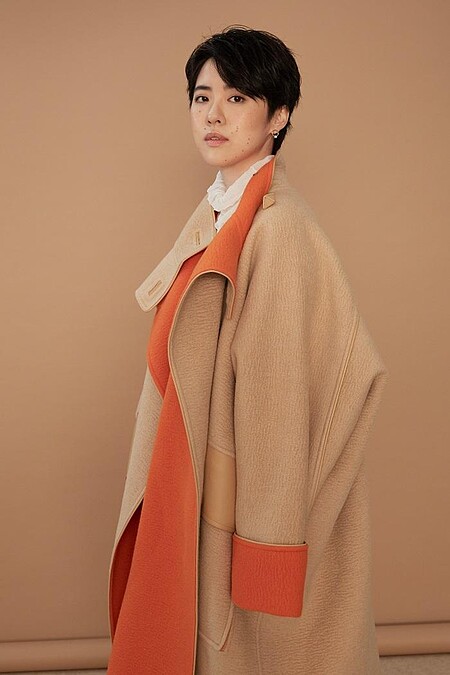 白高領透膚上衣 LOEWE；雙色駱駝斗篷大衣、米色馬褲、小牛皮長靴All by HERM&Egrave;S；幾何金耳扣、圓圈線條耳扣、圈形金耳環、字母線條戒指、金色戒指All by APM MONACO。