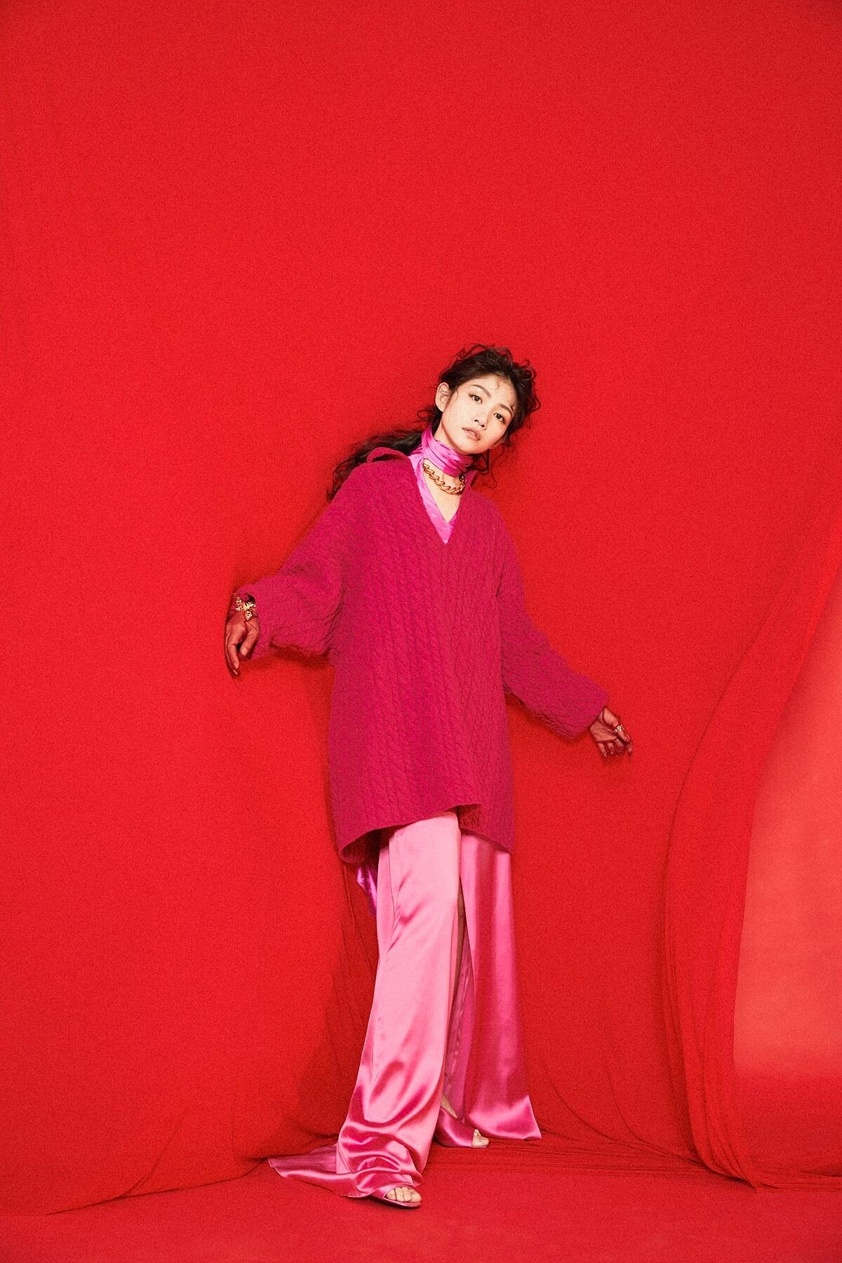 桃紅絲上衣、金色造型手環，both by CHLO&Eacute;；桃紅色開襟針織毛衣、桃紅絲緞開衩褲裙、金屬項鍊，all by BALENCIAGA；桃紅絲綢高跟涼鞋，PRADA；金色線條字母指環，APM MONACO；薄紗手套（造型師私物）。