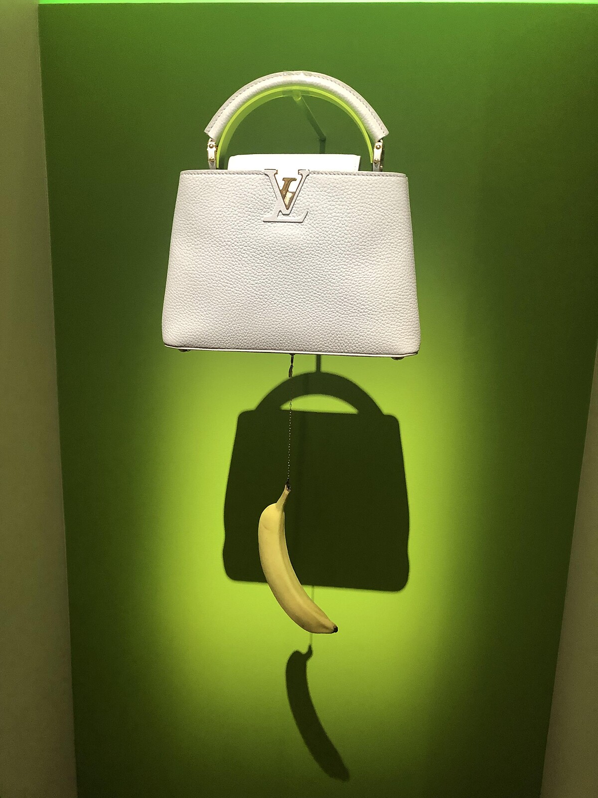 Urs Fischer的作品,以現代藝術戲謔的手法將香蕉吊於包款下方,大鬧時尚,卻也似藝術作品。其底下的香蕉可以換成蘋果或其他水果,這是真的不是笑話喔。