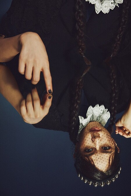 蕾絲披肩、羊毛長大衣，both by Prada；蕾絲裝飾針織衫，Chlo&eacute;；網紗裝飾髮飾，Red Valentino。