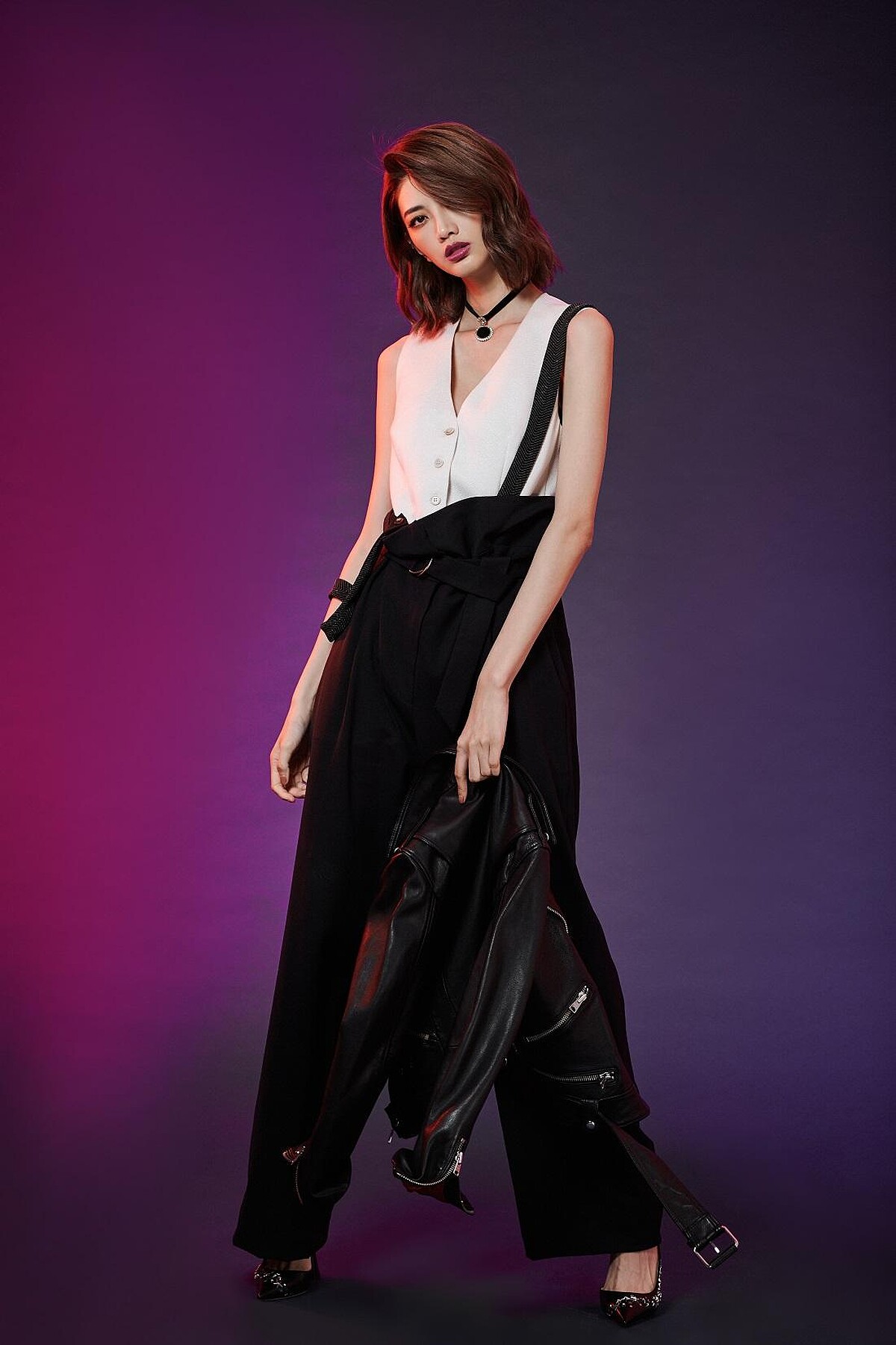 黑白拼接吊帶設計寬版連身褲，Brunello Cucinelli。黑色皮革騎士夾克，AllSaints。絲絨頸鏈，Swarovski。鉚釘飾高跟鞋，Jimmy Choo。