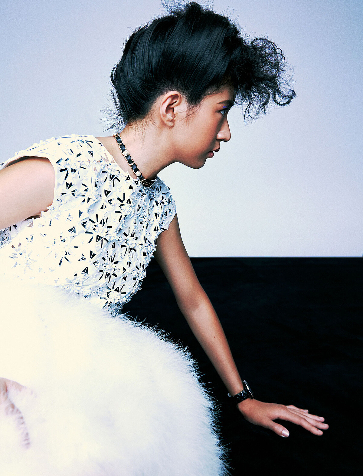 2. 羽飾洋裝、黑色厚底短靴、皮穿鍊腰帶、皮穿鍊頸鍊、皮穿鍊寬版手鐲、黑色高科技精密陶瓷 J12 腕錶，all by Chanel。