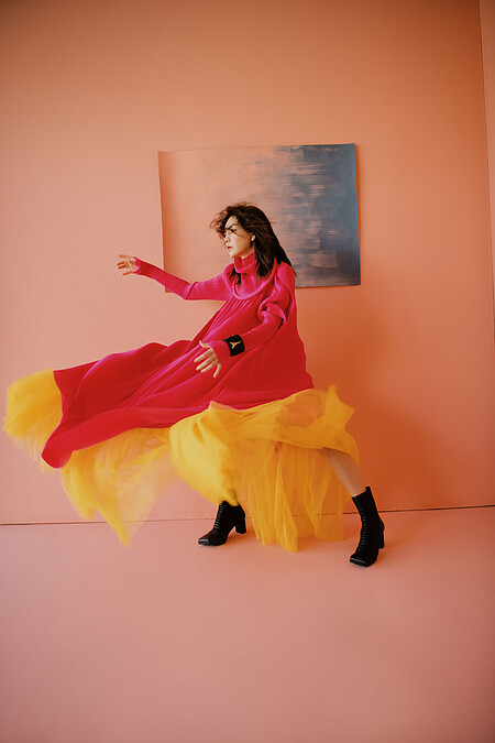 桃紅色針織洋裝、黑色粗跟靴、黑色寬版手鐲，all by Balenciaga；黃色網紗洋裝，No. 21 @ Yoox。