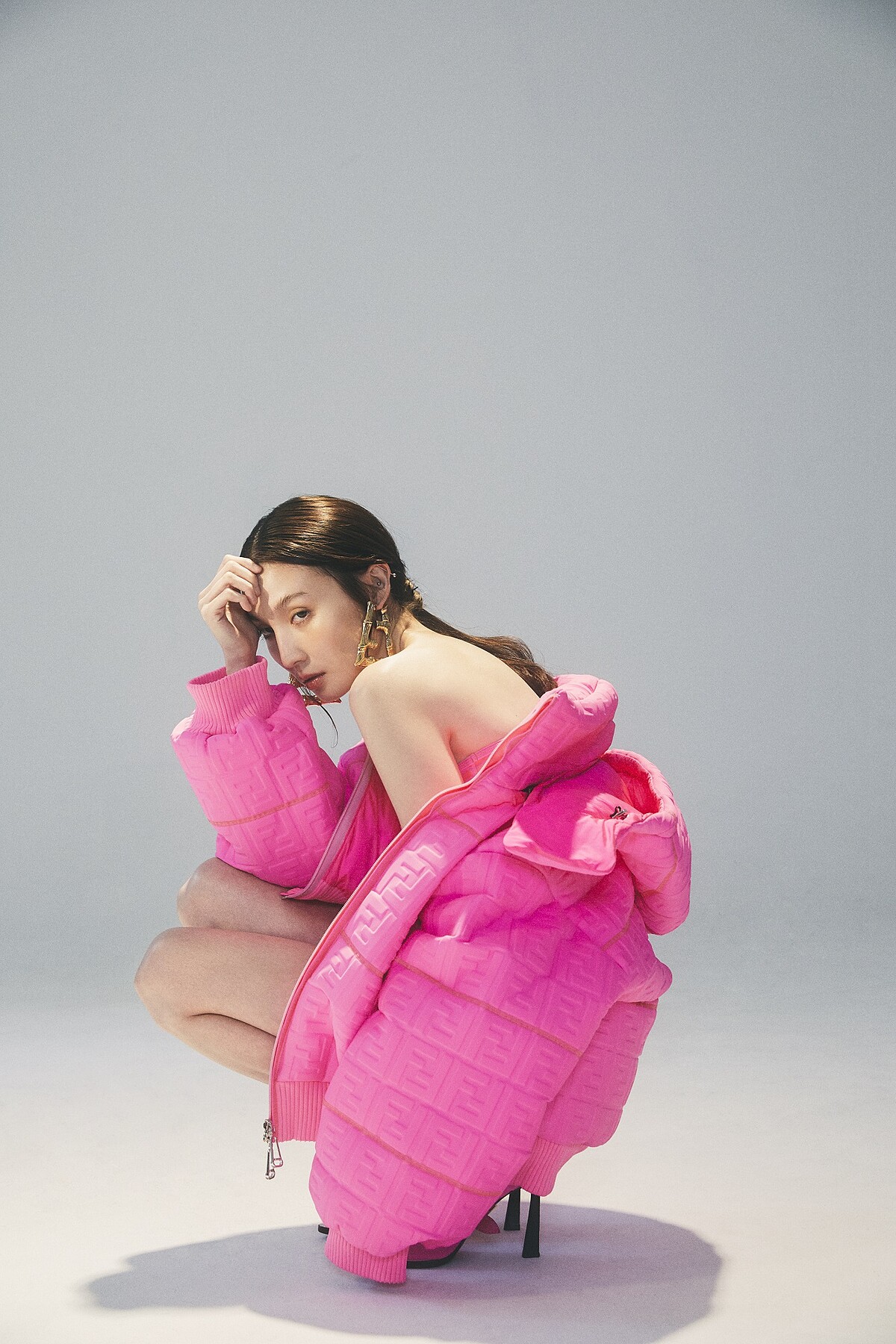 金色雕刻細節雙F字母耳環、螢光桃紅凸紋連帽外套、腰部鏤空單肩泳衣、桃紅色高跟鞋,all by Fendi。