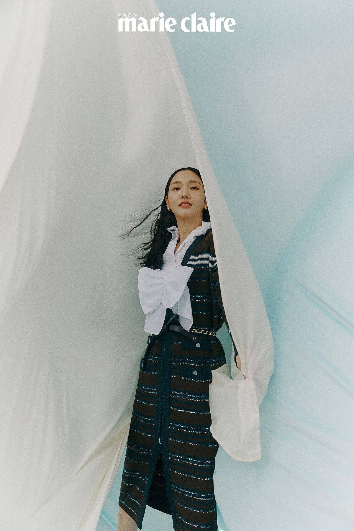 白色褶飾襯衫、白色蝴蝶結短背心、長版針織衫、雙C Logo寬版手鐲、皮穿繩金屬腰帶、Coco Crush 耳環，all by Chanel。