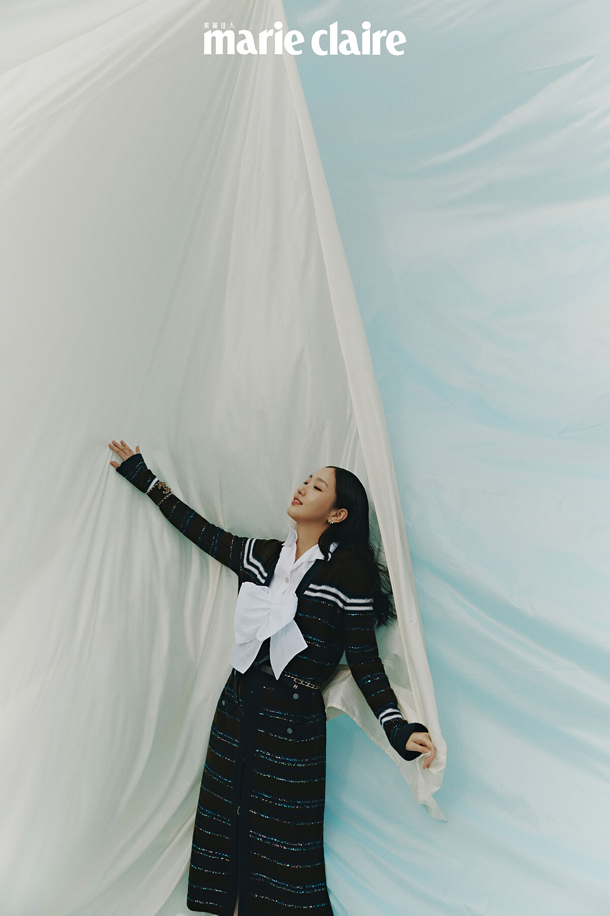 白色褶飾襯衫、白色蝴蝶結短背心、長版針織衫、雙C Logo寬版手鐲、皮穿繩金屬腰帶、Coco Crush 耳環，all by Chanel。