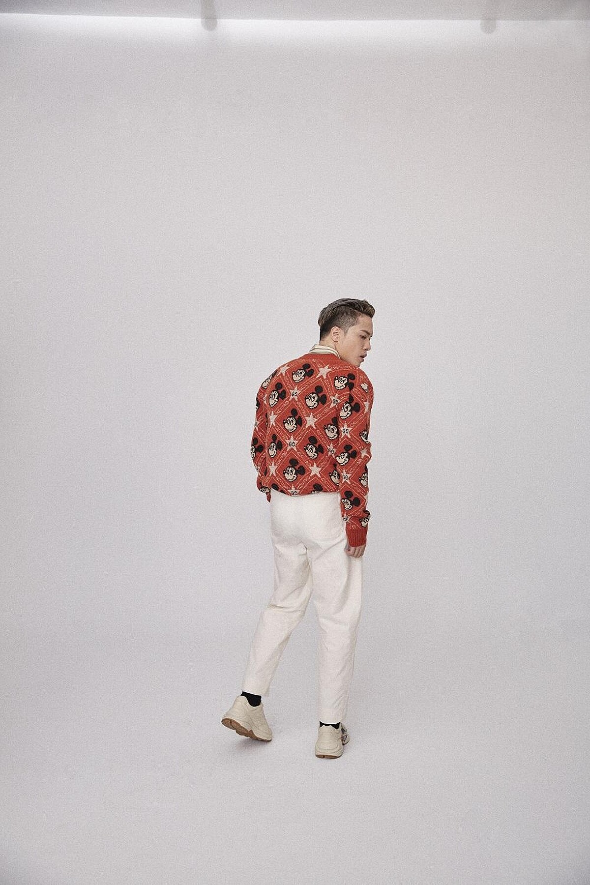 米老鼠圖紋上衣、襯衫、白色長褲、運動鞋，all by Gucci。