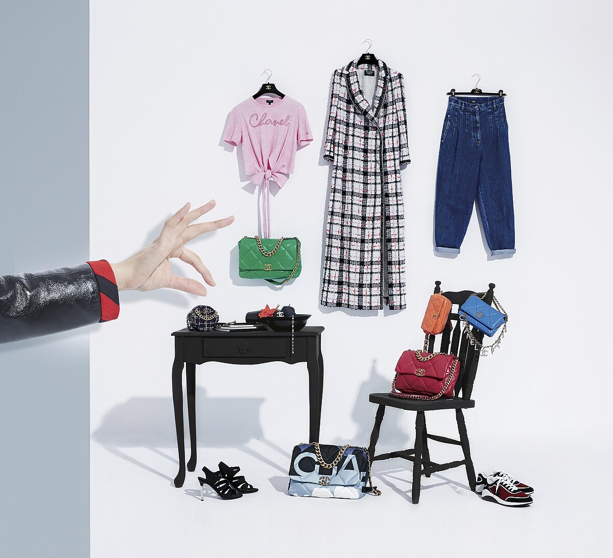 粉紅T恤、斜紋軟呢長外套、水洗牛仔褲、水晶鑲飾CHANEL字母腰鍊、藍色菱格紋皮革CHANEL 19小包、橘色菱格紋皮革CHANEL 19腰包、紅色菱格紋皮革CHANEL 19包_中型款、紅黑色拼接運動鞋、巴黎天際線印花CHANEL 19包_大型款、珍珠鞋跟涼鞋、紅黑格紋斜紋軟呢CHANEL 19圓形小包、真絲縐綢山茶花、珠飾雙C Logo長項鍊、綠色菱格紋皮革CHANEL 19包_大型款；All by CHANEL。