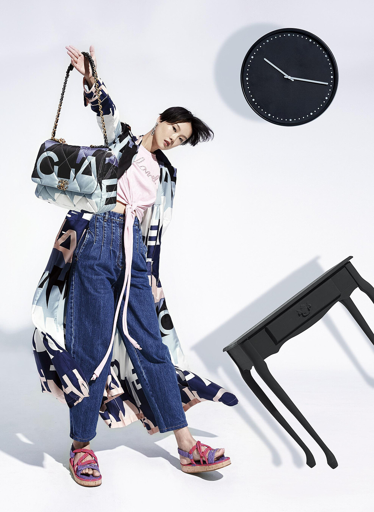 巴黎天際線印花CHANEL 19包_大型款、巴黎天際線印花絲質風衣外套、粉紅T恤、水晶鑲飾圈型耳環、水洗牛仔褲、粉紫色繫繩涼鞋；All by CHANEL。