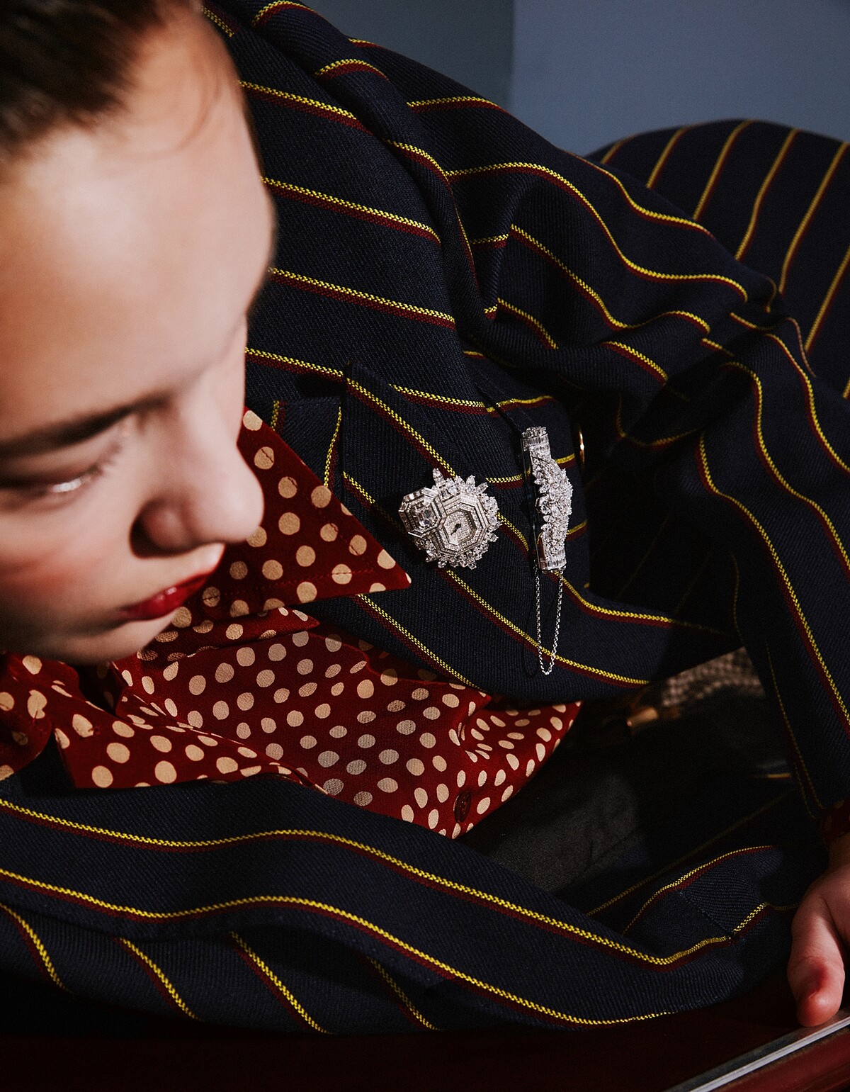 鑽石墜飾胸針、鑽石神秘錶胸針，both by Harry Winston。襯衫與西裝外套，both by Saint Laurent。