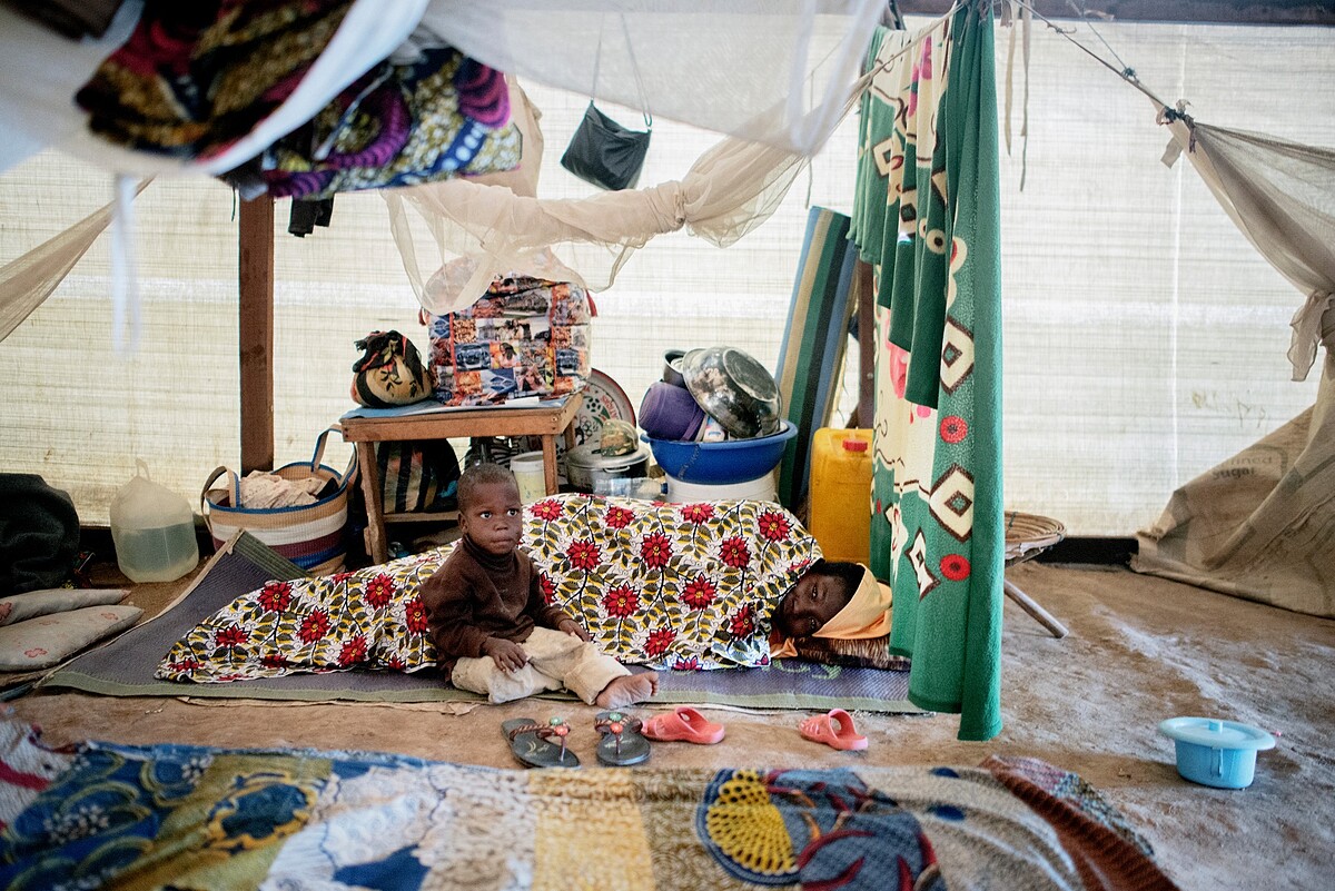中非共和國首都班基(Bangui)一處流離失所者營地內,一位來MSF診所接受治療的患者和他的小朋友。© Luca Sola