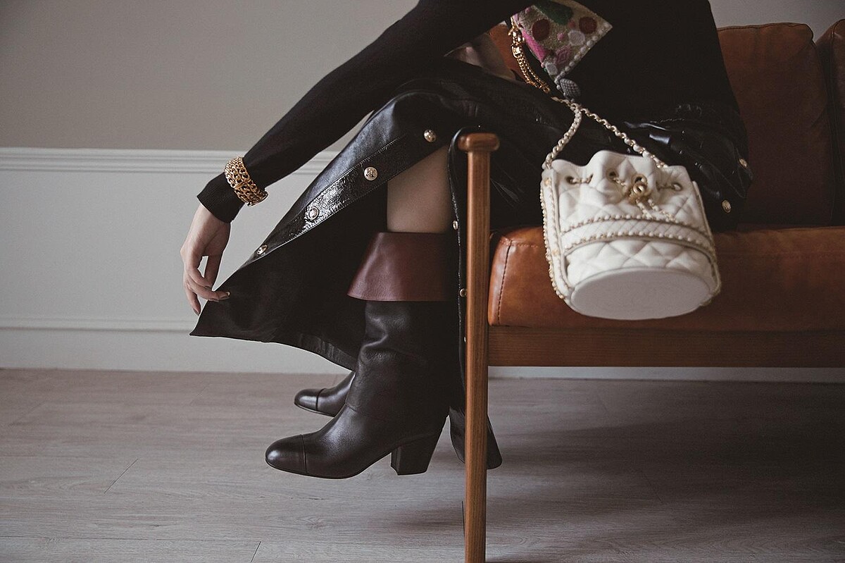 黑白拼接蕾絲緄邊洋裝、十字造型多層次珍珠串鍊、黑色十字造型高級樹脂手環，白色斜紋軟呢雙色鞋、粉色亮皮菱格紋珍珠背鍊皮夾、白色菱格紋皮革穿金屬鍊帶水桶包、紫紅色亮片刺繡斜紋軟呢2.55包、棕色皮革雙色鞋、黑色菱格紋CHANEL 19手機包，CHANEL。