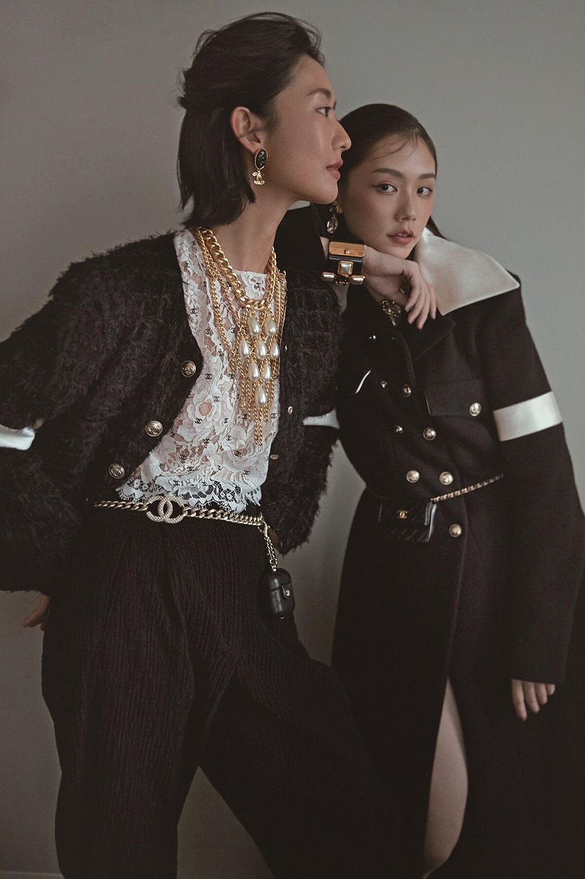 （左）CHANEL logo刺繡短版蕾絲上衣、黑色皮革吸釦馬褲、黑色絲絨臂帶斜紋軟呢外套、水晶鑲嵌雙C Logo金屬腰鍊、黑色菱格紋皮革迷你掛飾耳機包、珍珠裝飾領巾造型菱格紋金屬多層次項鍊、黑色樹酯金屬雙C Logo耳環。(右)黑色羊毛飾以絲緞領口與臂帶大衣、珍珠裝飾領巾造型菱格紋金屬項鍊、寶石耳環、黑色菱格紋皮革迷你腰包，CHANEL。