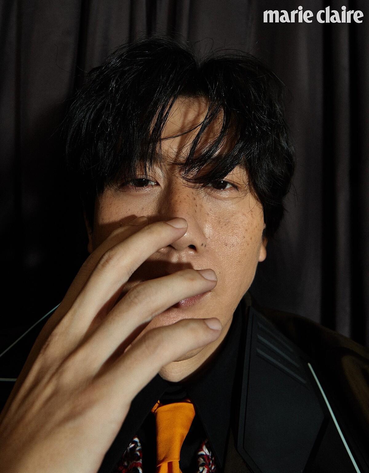 黑色襯衫、明黃領帶、鉤織混紡毛衣、咖啡色尼龍長版風衣、黑長褲、厚底紳士鞋，all by Prada。