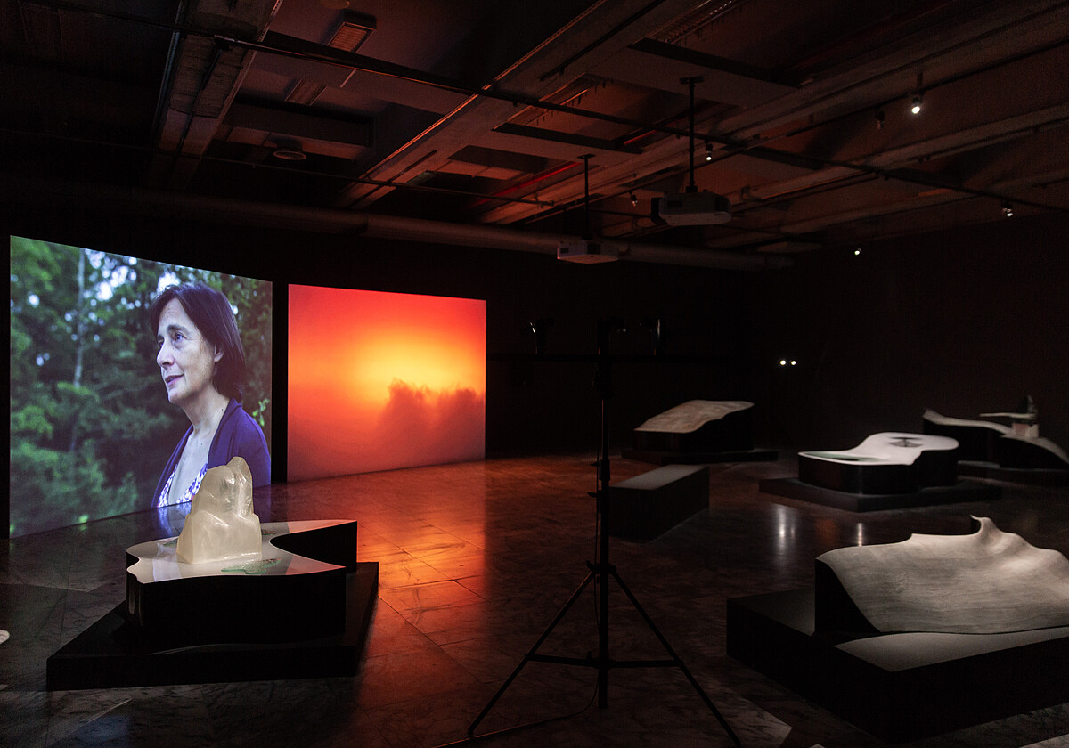 雋．巴爾達扎＋皮耶．保茲，《Mass（質量／彌撒）》，2020，雙頻道錄像、木頭、泡沫、綜維素、聚酯樹脂、水性顏料、石膏、聚甲基丙烯酸甲酯薄片、人造植物、緩衝器、鋼、舞臺燈、燈架，尺寸視空間而定。圖像由藝術家及臺北市立美術館提供。