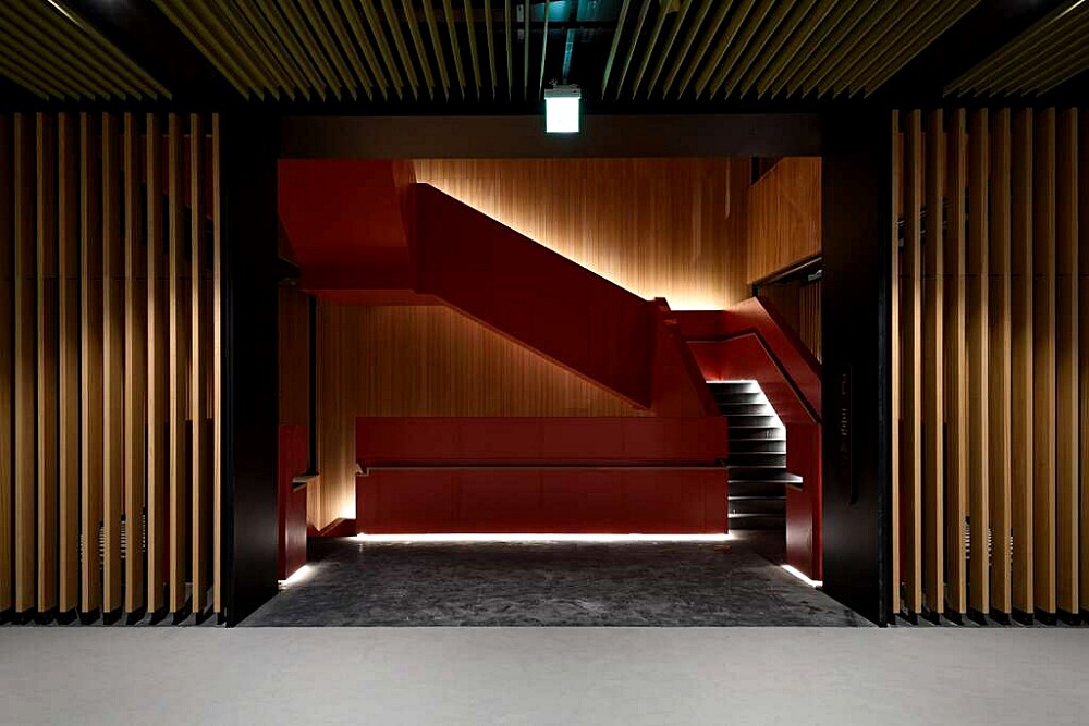 貫穿全樓層的大紅樓梯,為空間增添熱情