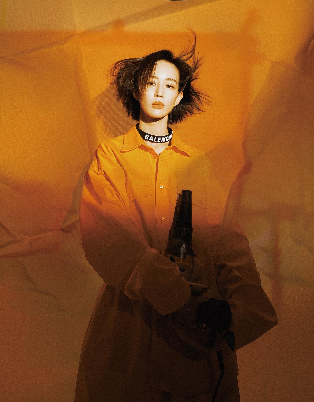 橘色襯衫、短褲、橡膠字母頸鍊，all by Balenciaga。