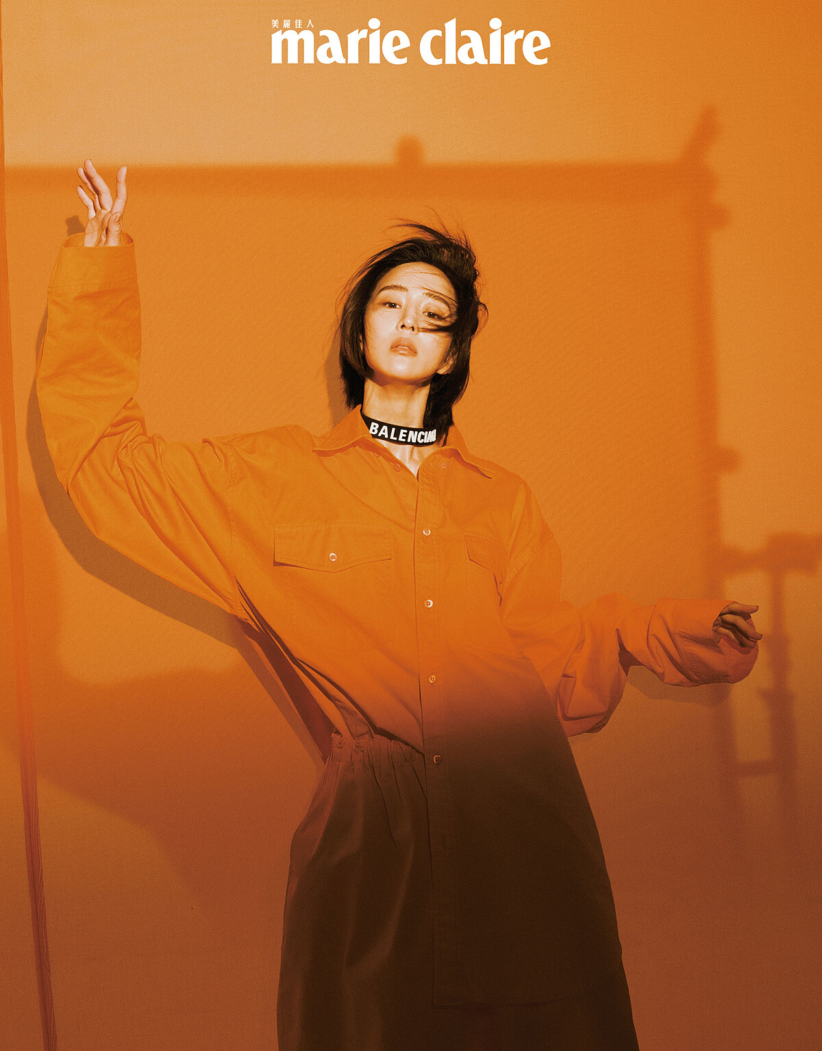 橘色襯衫、短褲、橡膠字母頸鍊，all by Balenciaga。