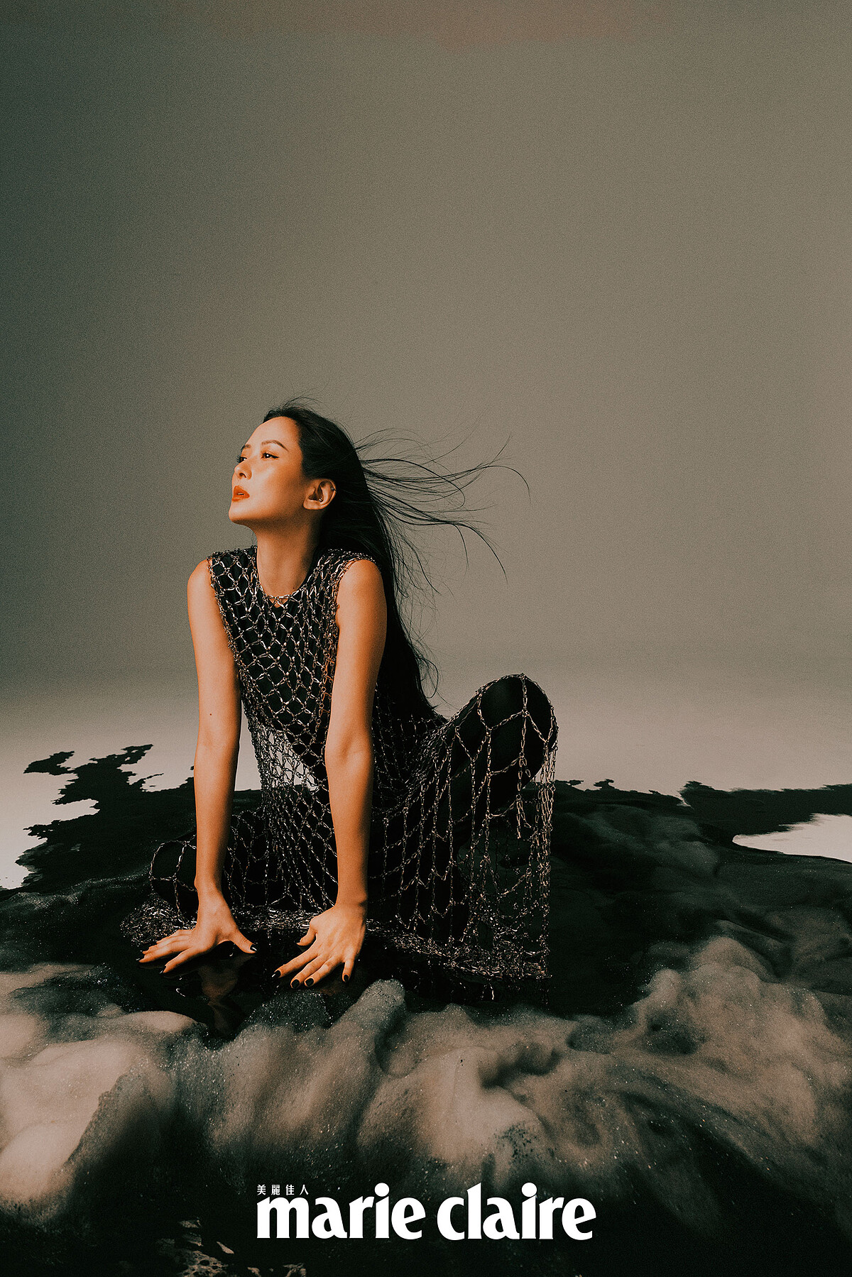 黑色背心、黑色連身鞋褲、水晶鑲嵌網狀罩衫，all by Balenciaga。