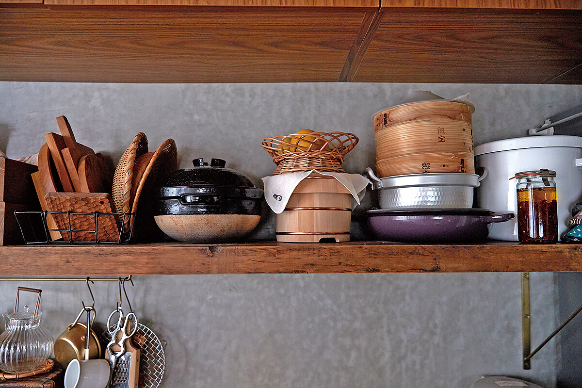 爐台背後是開放式的木頭陳列架，把喜歡的鍋具擺出來，器具顏色也規劃過，木質、玻璃、銅色，看起來不雜亂又有風格。