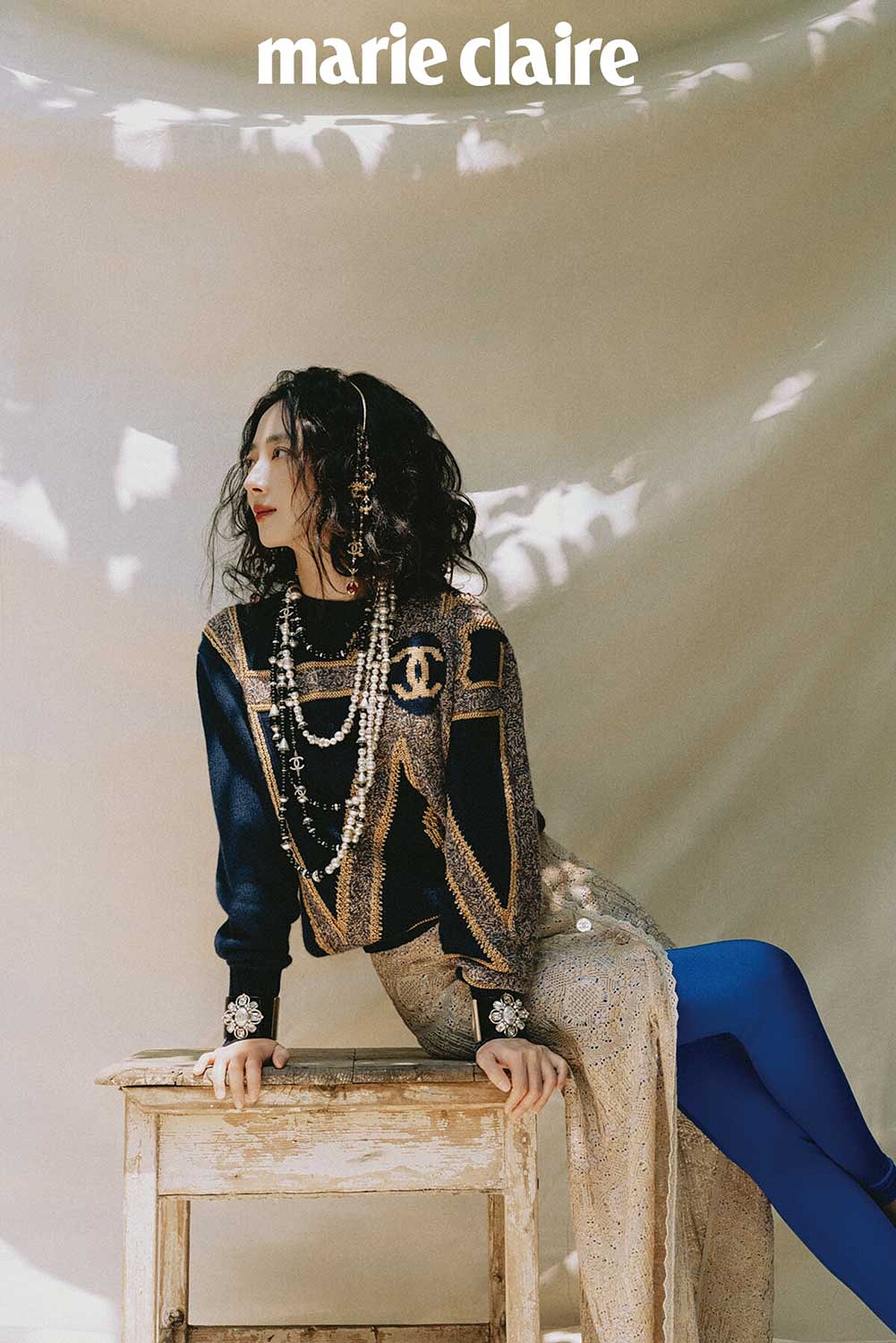 海軍藍金色城堡花園建築風格刺繡毛衣、金色嫘縈開岔長裙、亮藍色 Jersey 針織貼身褲、金屬多彩寶石流蘇造型髮箍、金屬黑白幻象珍珠多層次長項鍊、黑色高級樹脂水晶鑲飾幻象珍珠手環，all by CHANEL。