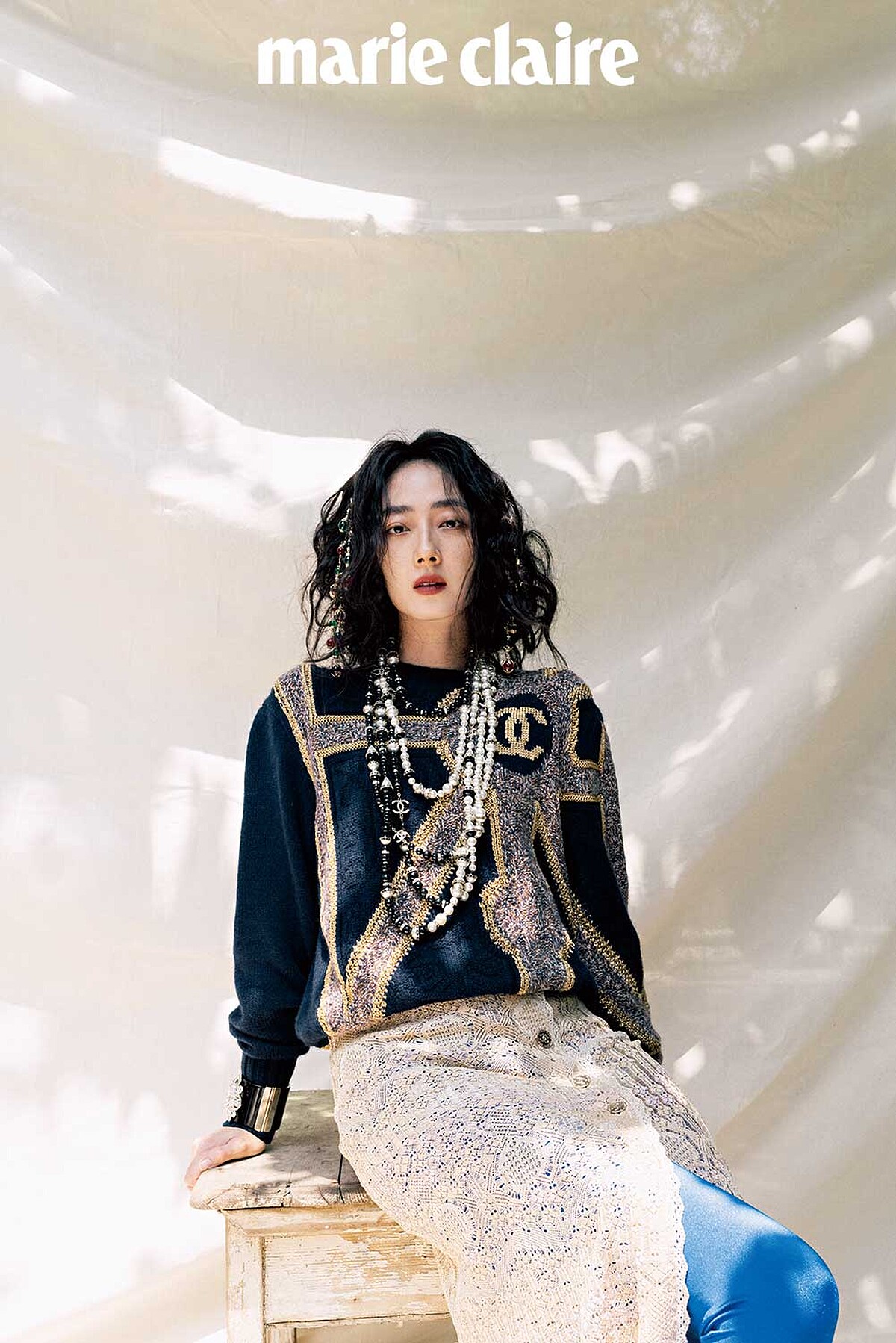 海軍藍金色城堡花園建築風格刺繡毛衣、金色嫘縈開岔長裙、亮藍色 Jersey 針織貼身褲、金屬多彩寶石流蘇造型髮箍、金屬黑白幻象珍珠多層次長項鍊、黑色高級樹脂水晶鑲飾幻象珍珠手環，all by CHANEL。