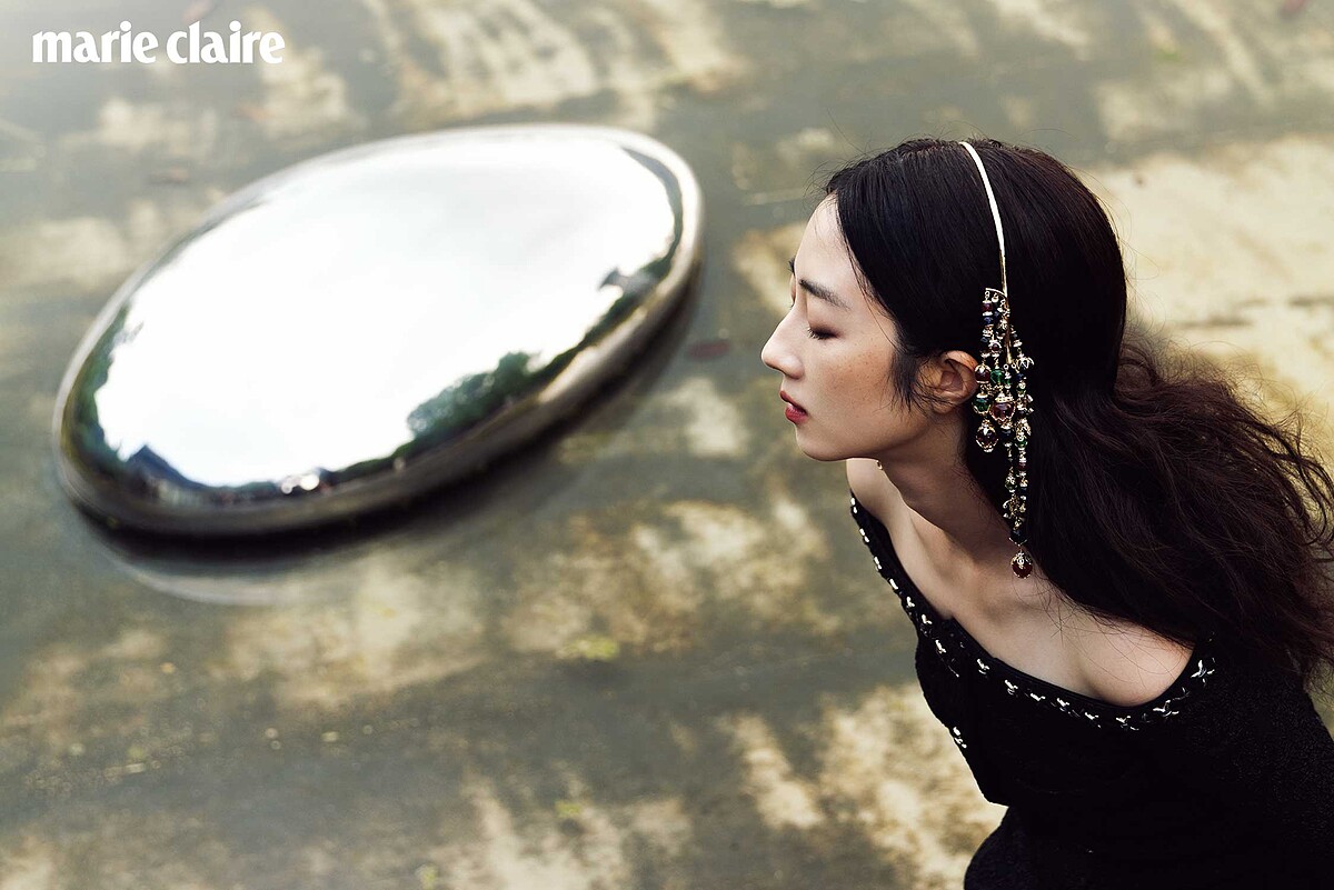 黑色幻彩Jersey金絲緄邊飾以珠寶十字架鈕扣外套、黑色絲絨飾以金幣刺繡與喬其紗蝴蝶結長褲、金屬多彩寶石流蘇造型髮箍，all by CHANEL。