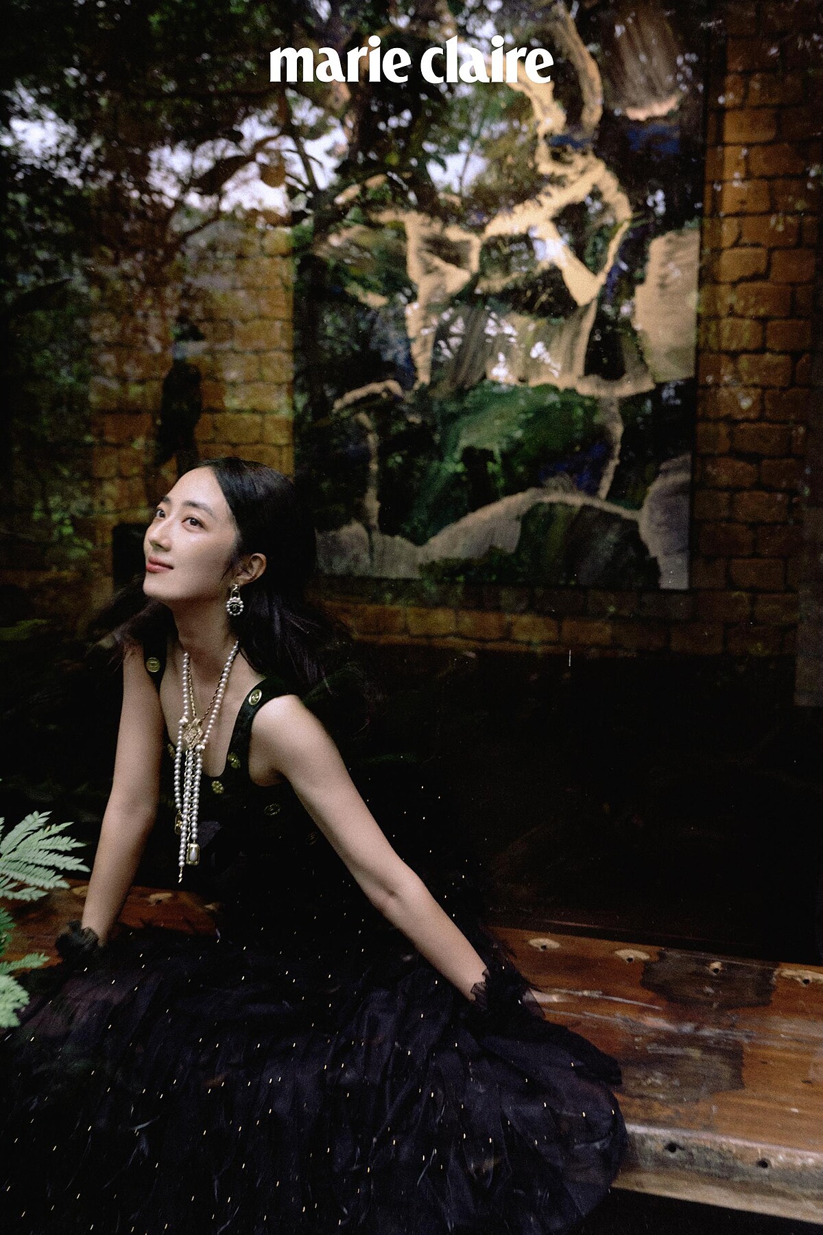 黑色絲絨飾以金幣刺繡上衣、黑色真絲綢紗羽毛飾以金色幻象珍珠刺繡長裙、黑色天鵝絨手套飾以蕾絲荷葉緄邊、金屬幻象珍珠皮穿鏈造型徽章式多層次長項鍊、金屬多彩寶石水晶鑲飾墜式耳環，all by CHANEL。