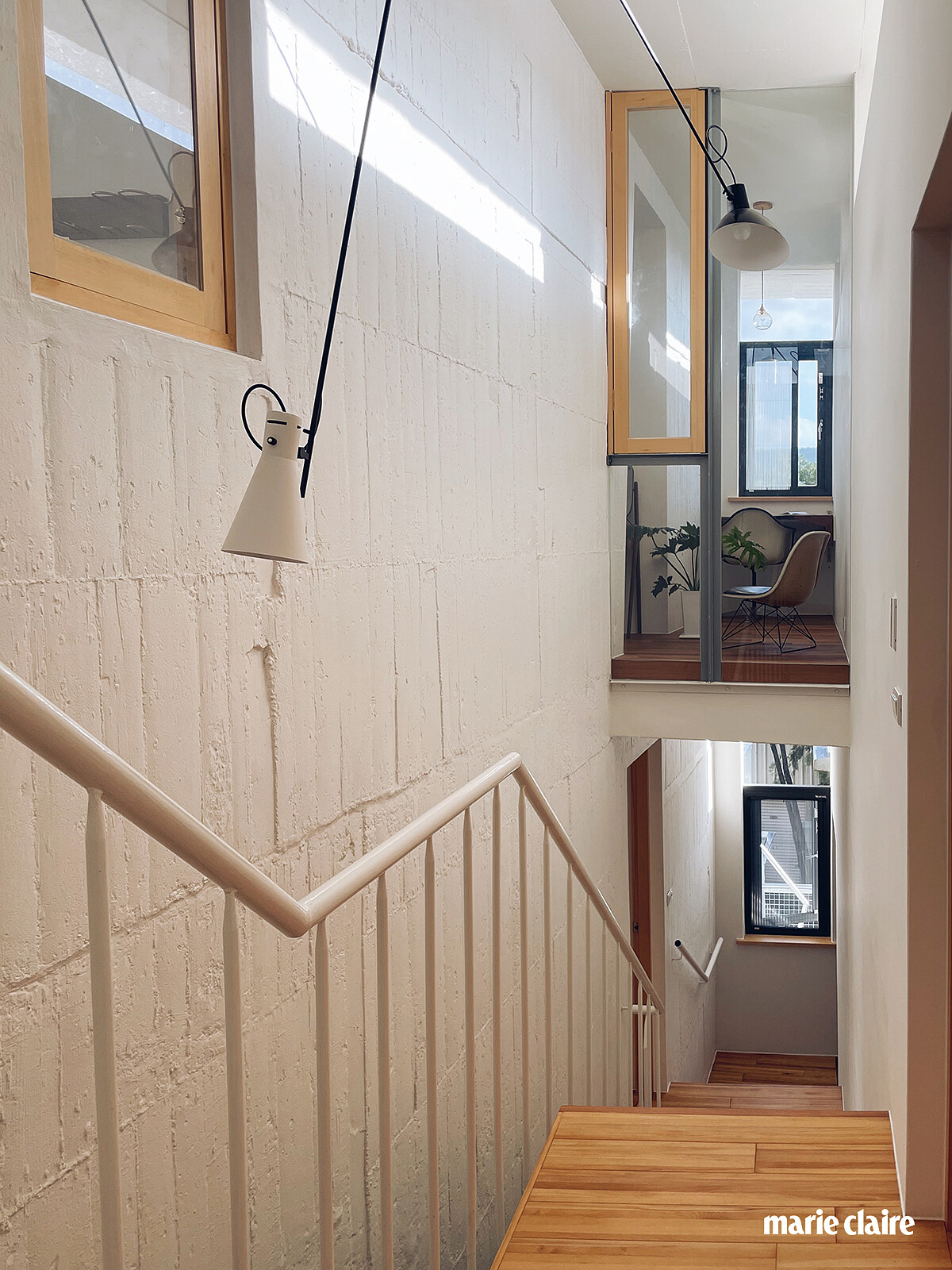 樓梯與天井空間是整棟建築的靈魂所在，傍晚夕陽光線會從屋頂反射下來，照映在模板牆面，使得牆壁白色塗料成了粉色溫暖的質地，十分迷人。