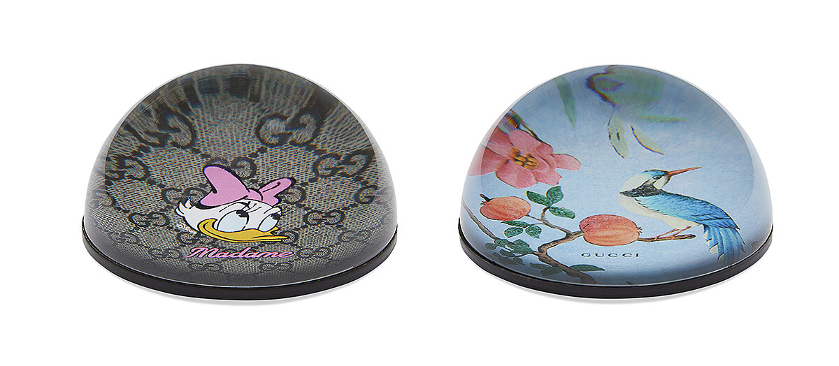 (右)粉色GG緹花唐老鴨圖案紙鎮,NT9,100元、(左)多色塗繪印花紙鎮,NT9,100。