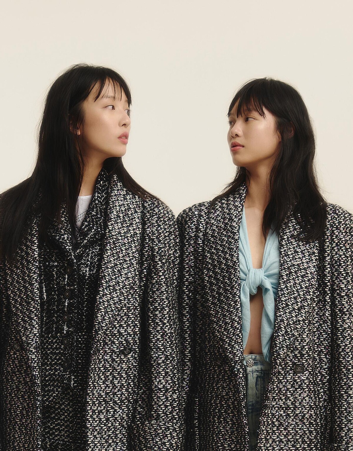 (左)黑米色格紋斜紋軟呢背心與同款開岔裙、內搭白色水晶鑲飾 Jersey 布料上衣、幻彩斜紋軟呢外套，all by CHANEL。(右)淡藍色羊毛繫腰造型毛衣、淡藍色雙 C Logo 印花丹寧布料牛仔褲、幻彩斜紋軟呢外套，all by CHANEL。