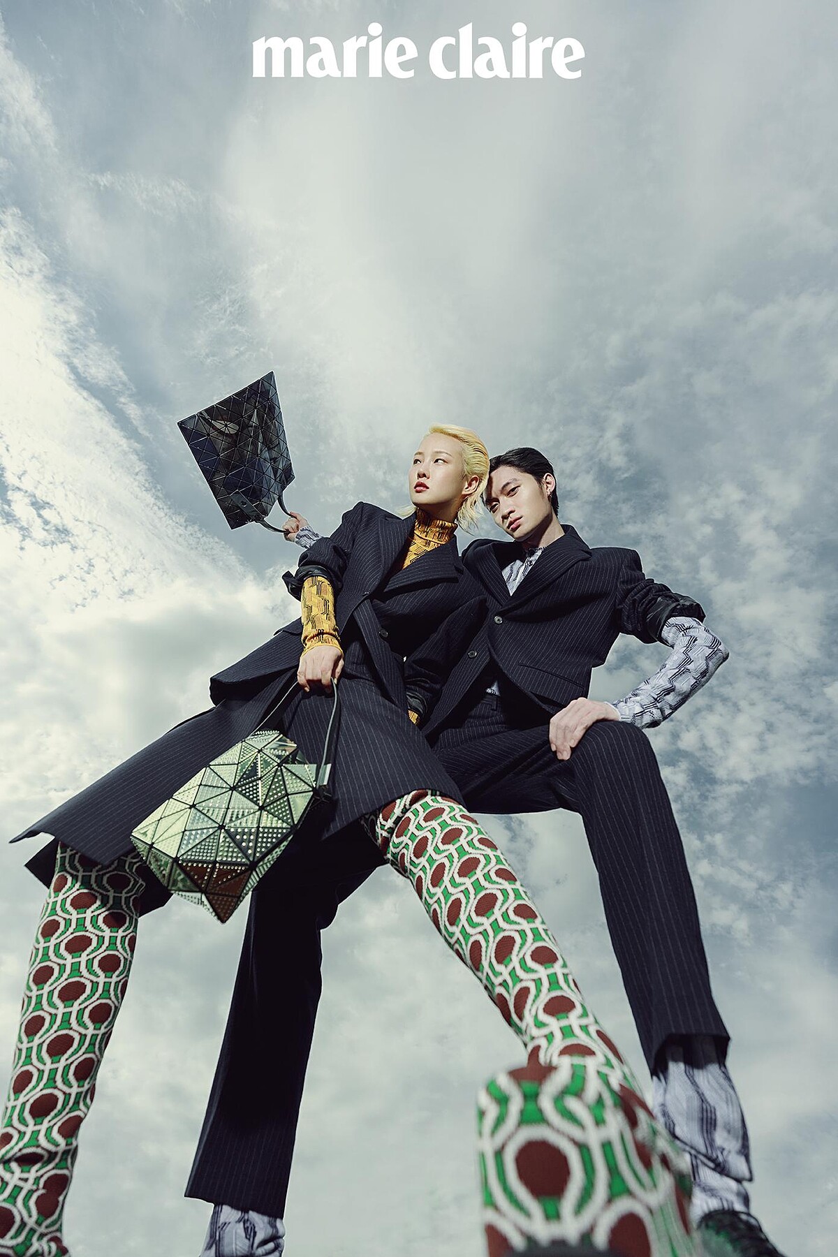 Gia Tang：黑色西裝外套、黑色印花裙裝、綠色印花長靴，all by Prada；綠色幾何小包，Issey Miyake。 Zachary Chou：黑色西裝外套、藍色印花連身衣，黑色西裝長褲，all by Prada；印花手提袋，Issey Mitake。