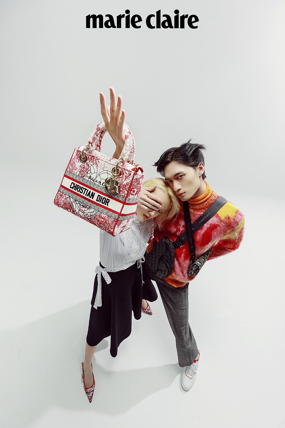 Gia Tang：白色刺繡襯衫、黑色裙裝、紅色刺繡尖頭鞋、紅色刺繡手提包，all by Dior。 Zachary Chou：紅色印花針織衫、芥末黃高領上衣、灰色西裝長褲、白色球鞋、黑色刺繡馬鞍包、灰色刺繡馬鞍包，all by Dior。
