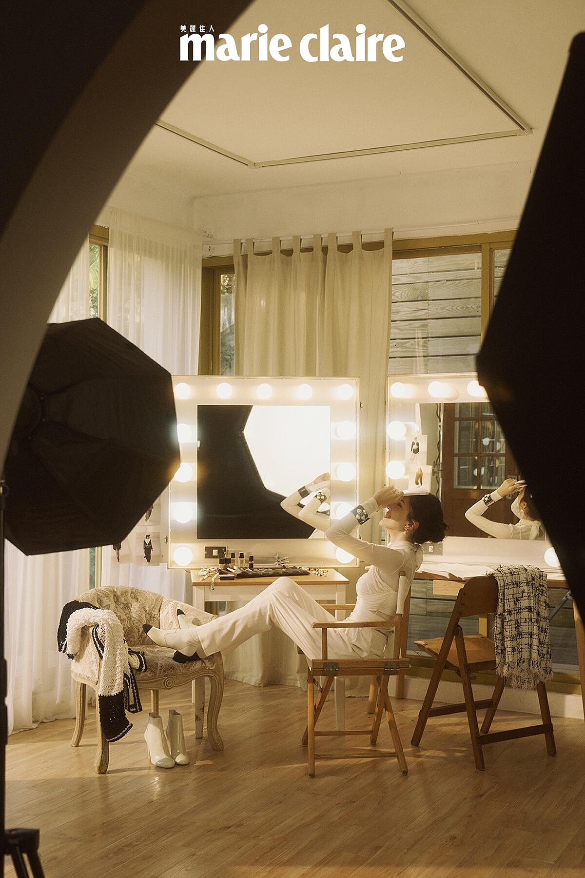 白色真絲縐紗綁帶造型上衣與同款長褲、 雙色皮革短靴、黑色高級樹脂馬爾他十字手環、金屬高級樹脂愛心造型耳環、金屬幻象珍珠腰鍊，all by CHANEL。