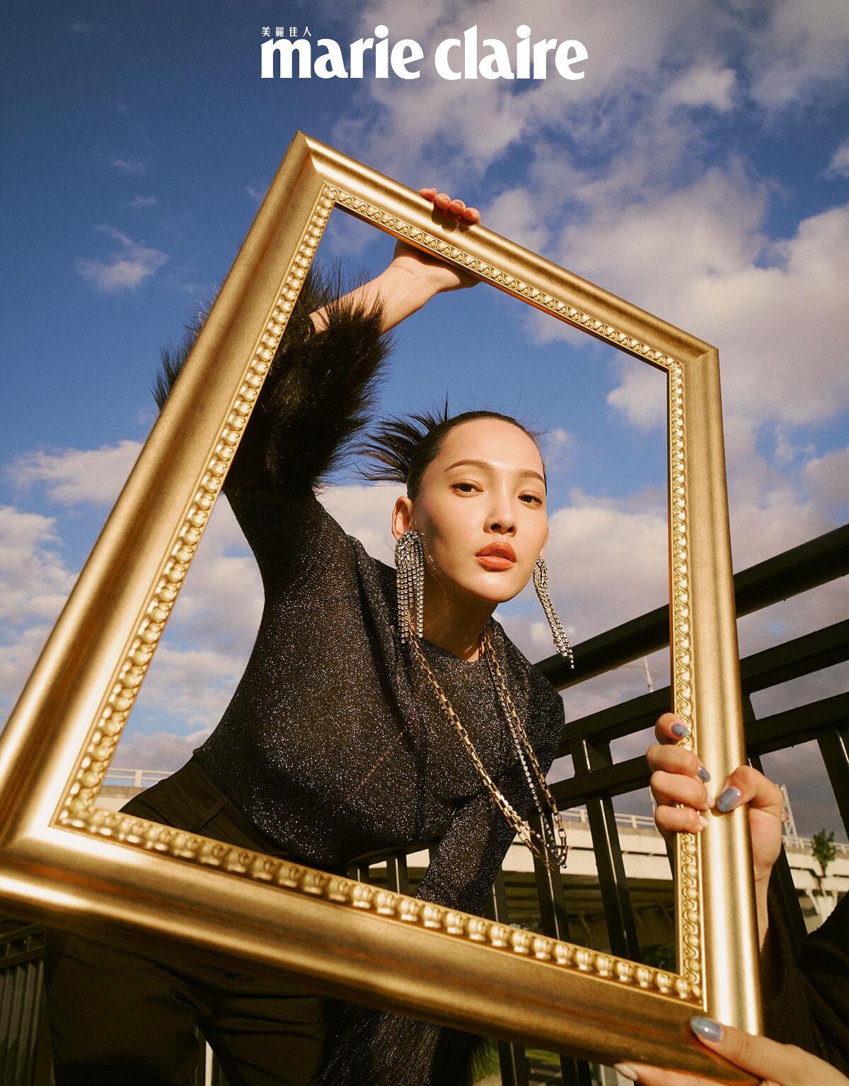 黑色毛袖上衣、黑色短褲、鑽飾流蘇耳環、金銀項鍊，all by Saint Laurent。