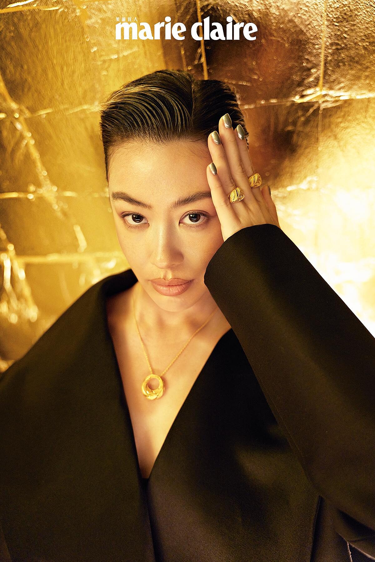 黑色外套，Loewe。金羽鳳凰系列吊墜、手環、耳環、戒指，all by Just Gold。