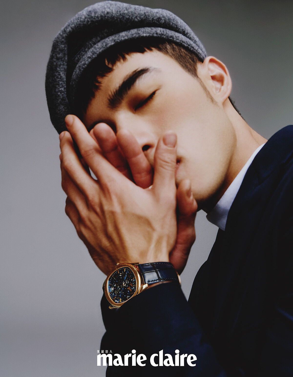 白色高領衫、深藍色附扣式腰帶西裝外套、寬版西裝褲，all by Dior Men；灰色蓓蕾帽，Kangol。Piaget Polo 系列18K玫瑰金鏤空機芯超薄腕錶、Piaget Possession 系列18K玫瑰金鑽石戒指、18K玫瑰金白玉髓鑽石墜鍊、18K白金鑽石墜鍊，all by Piaget。