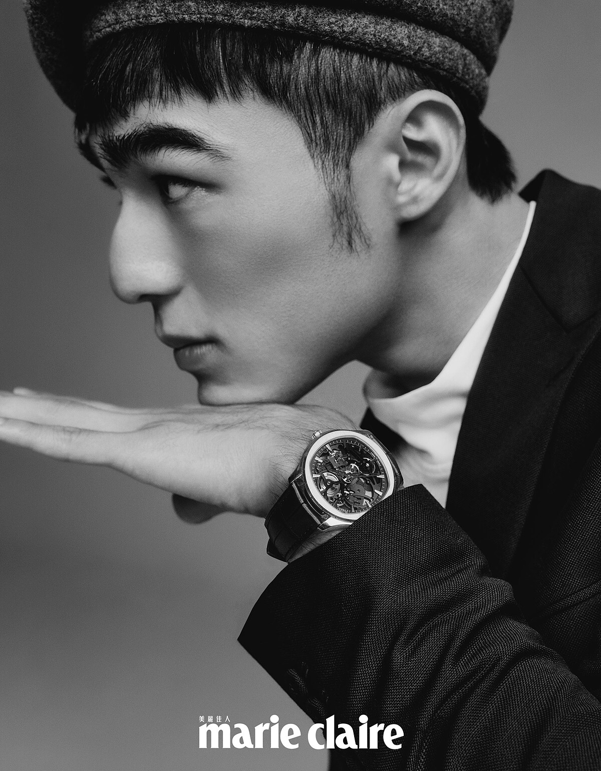 白色高領衫、深藍色附扣式腰帶西裝外套、寬版西裝褲，all by Dior Men；灰色蓓蕾帽，Kangol。Piaget Polo 系列18K玫瑰金鏤空機芯超薄腕錶、Piaget Possession 系列18K玫瑰金鑽石戒指、18K玫瑰金白玉髓鑽石墜鍊、18K白金鑽石墜鍊，all by Piaget。