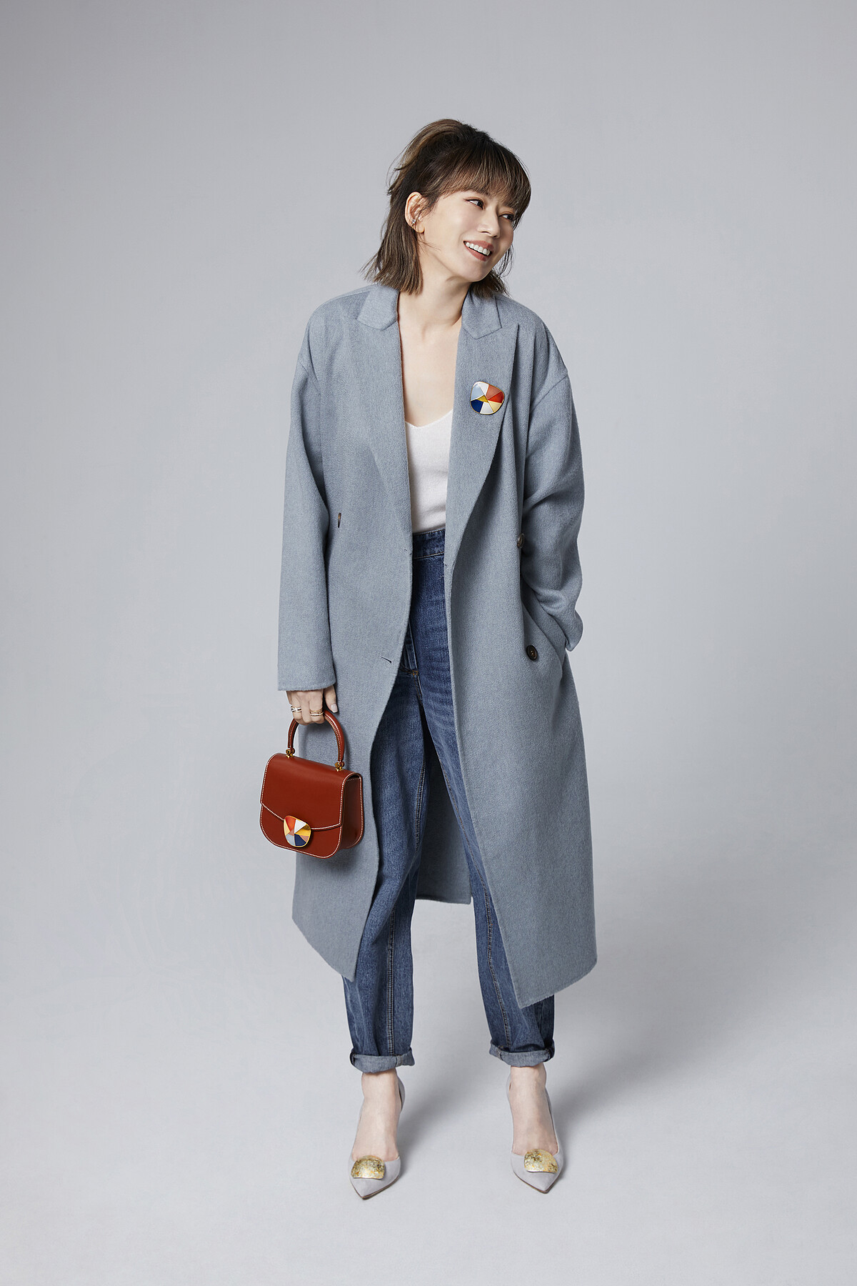 Melody以 SAUVEREIGN Cubik系列傳世金箔扣作為胸針裝飾並搭配於Aphrodite包款上，腳踩 Merida 75金箔跟鞋搭配 Pure系列傳世金箔扣。