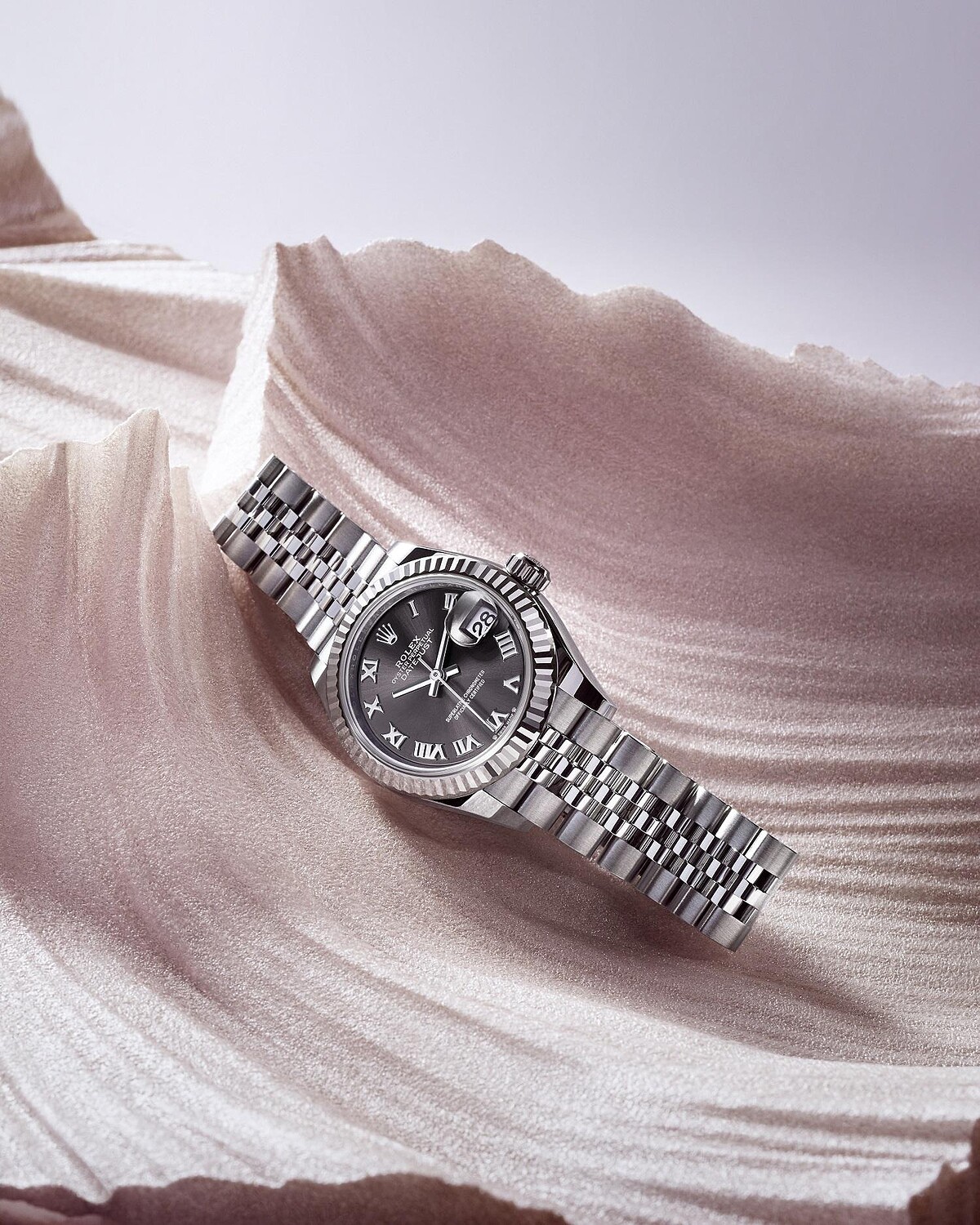 Lady-Datejust白色黃金鋼款,搭配三角坑紋外圈,以及羅馬數字鐘點標記深灰色錶面©RolexUlysse Fréchelin