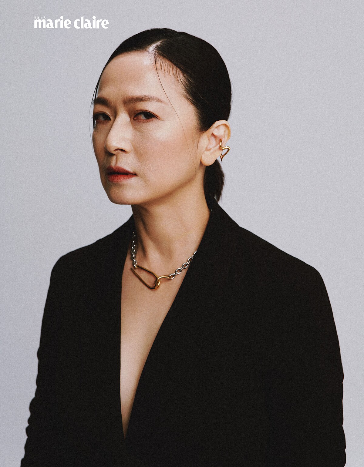 黑色西裝外套、黑色紗裙、黑色窄版皮帶；all by Allsaints；金色項鍊、金色耳骨夾，both by VANN；綠色耳環，Prada。