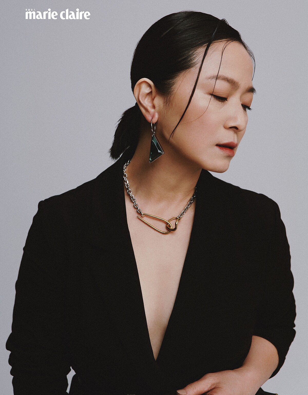 黑色西裝外套、黑色紗裙、黑色窄版皮帶；all by Allsaints；金色項鍊、金色耳骨夾，both by VANN；綠色耳環，Prada。