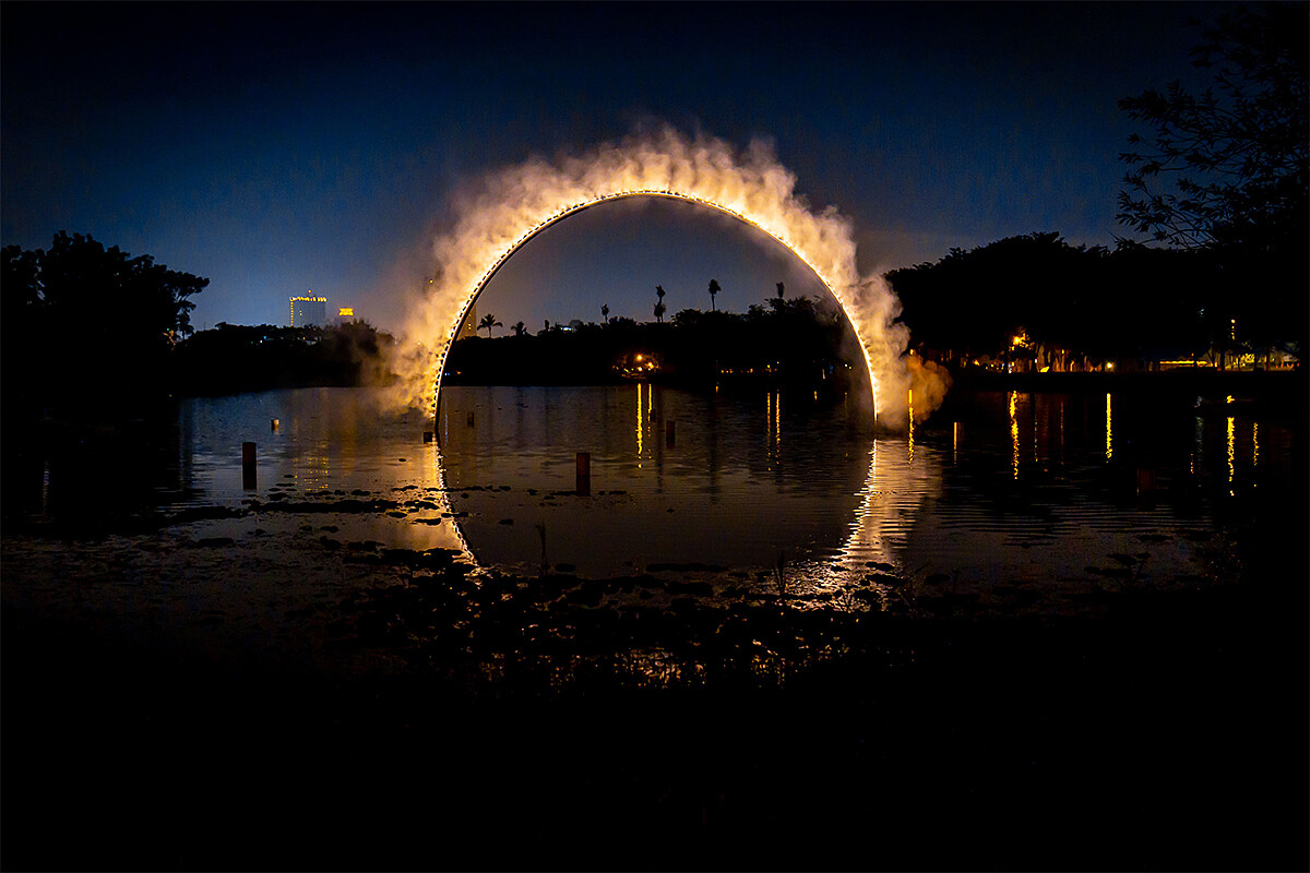 【Arc Zero Eclipse 弧 零：月食】利用水中倒影創造一個完整且對稱的圓形霧環，夜間像火一樣的發光，此作品將永久設置於高雄。（地點：衛武營北湖）