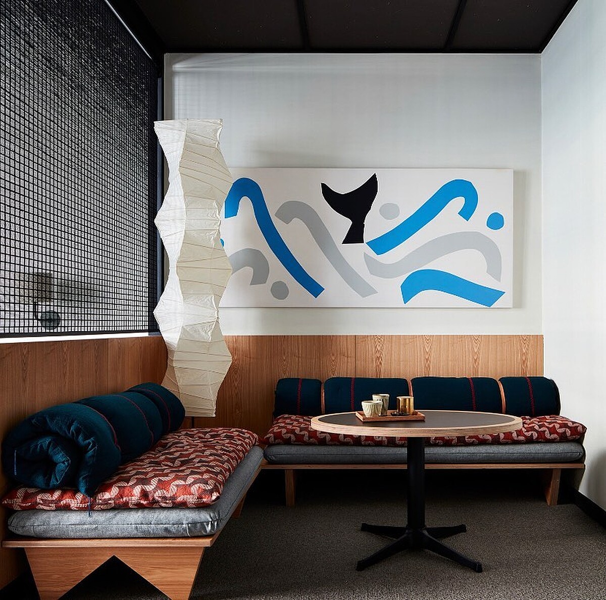 房間內部大量使用日本紡織品，角落為現代雕塑大師野口勇的燈具設計燈具 AKARI 系列的落地燈。