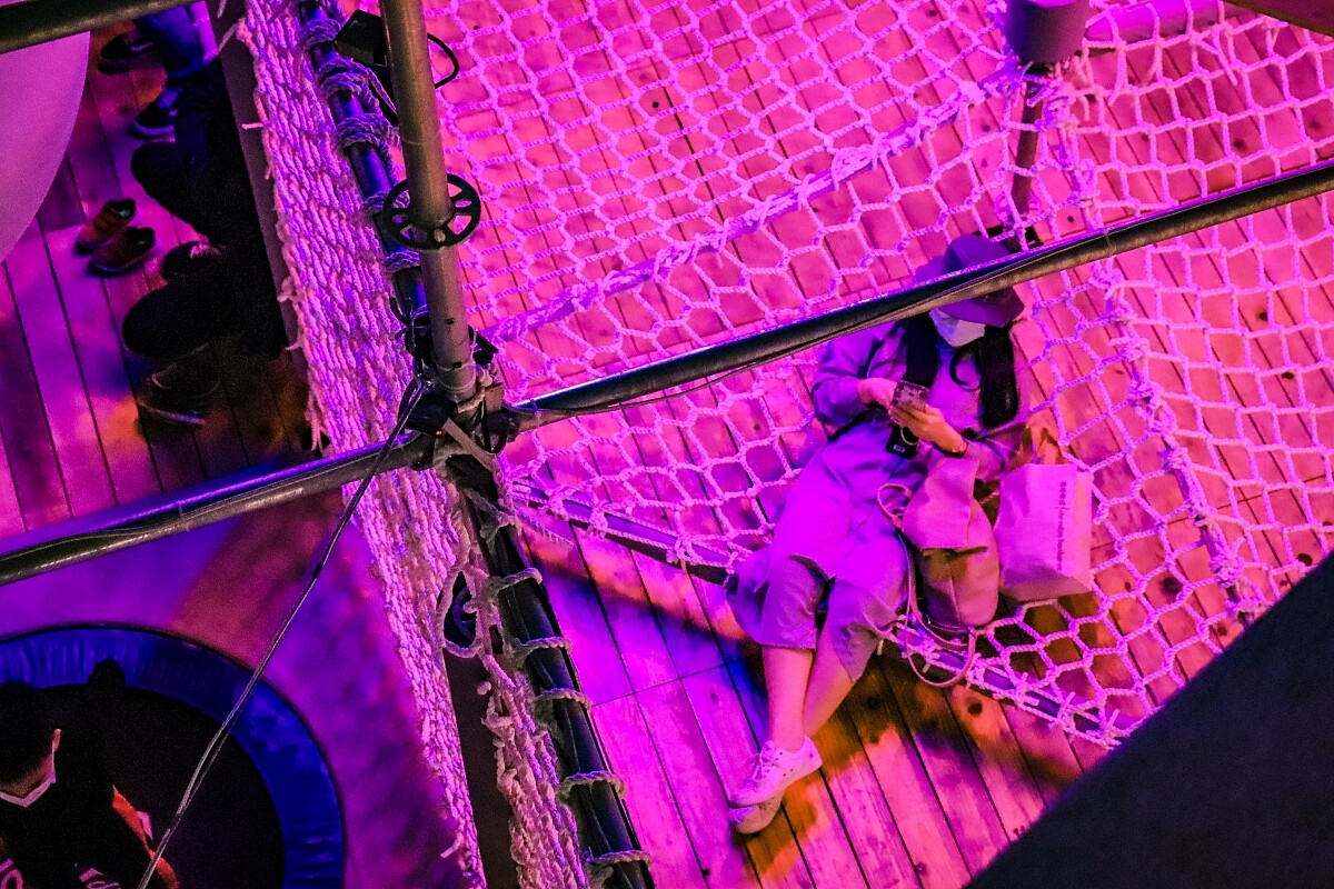 網繩區的一隅，輕盈的木結構加上穿插或坐或躺的休憩座位，展現最 CHILL 的生活場景。