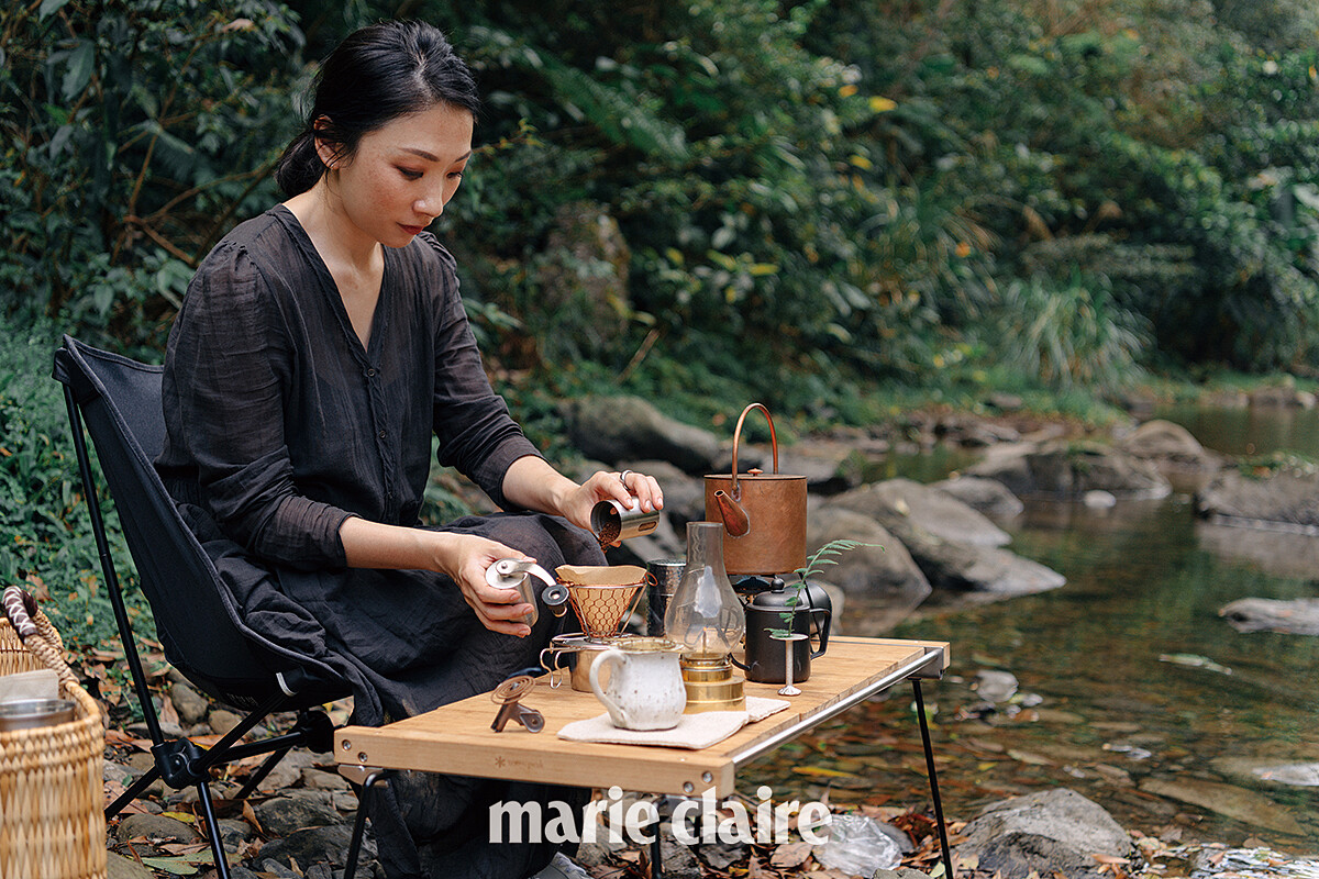 對於戶外環境感到相當自在，熟練的攤開桌面，流暢的擺設道具，接著慢條斯理的泡上一杯咖啡。