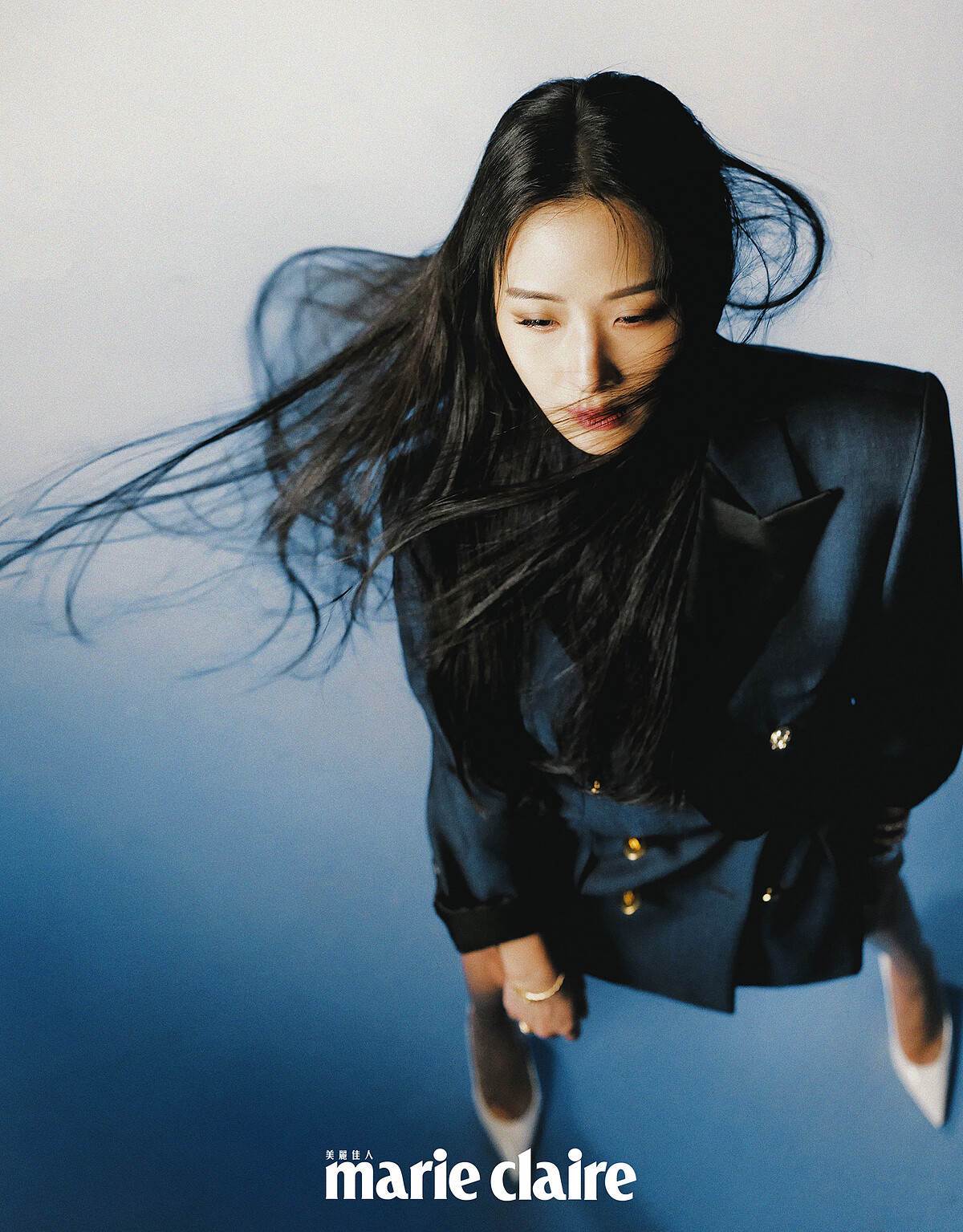 玫瑰金半鑽腕錶、玫瑰金鑲鑽手環、玫瑰金鑲鑽戒指、白K金鑲鑽戒指，all by BVLGARI；藍色雙排扣西裝外套，Louis Vuitton；黑色亮面短褲，CELINE；白色高跟鞋，Christian Louboutin。