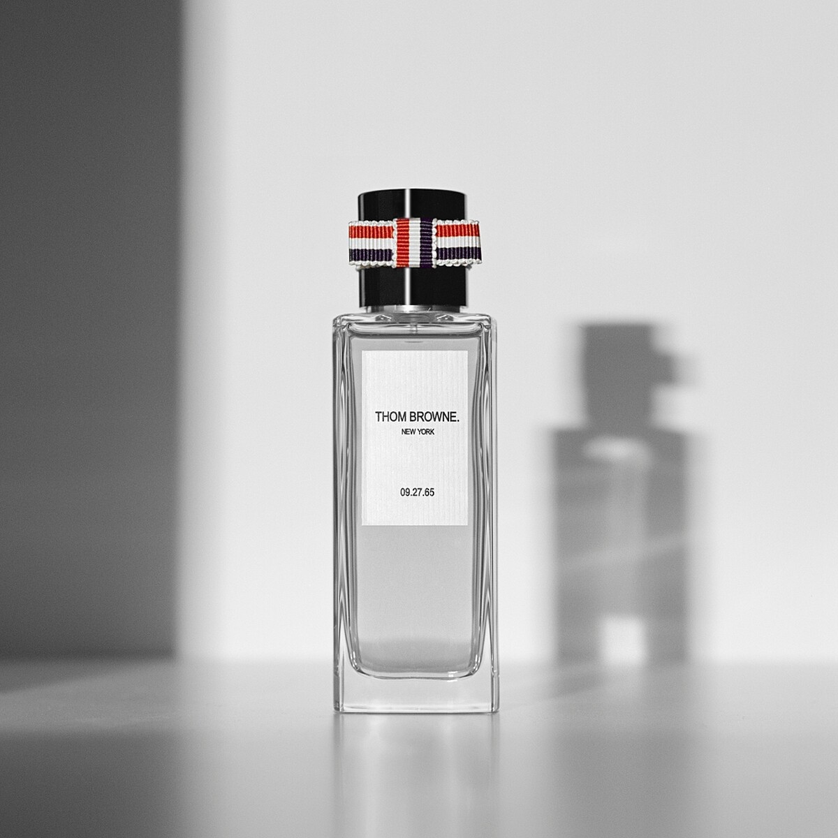 THOM BROWNE中性香水的瓶蓋以經典紅白藍三色羅緞環繞著黑色漆面，瓶身則是厚實的水晶玻璃。